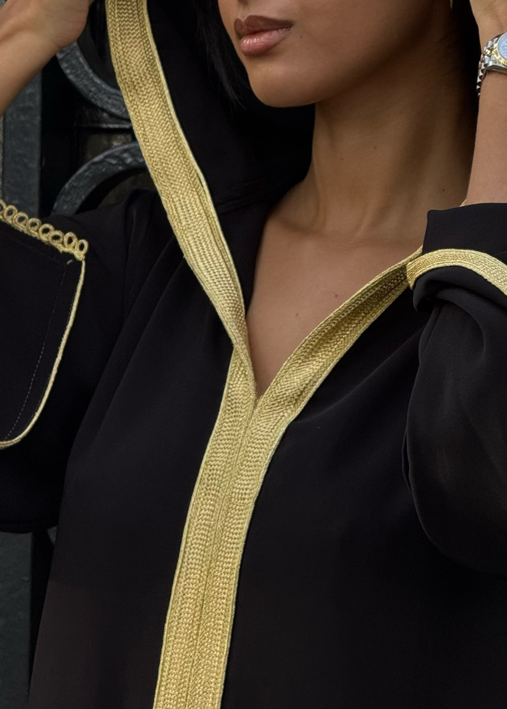 صورة مقربة لسفيفا ذهبية مخاطة يدوياً على كريب الحرير الأسود