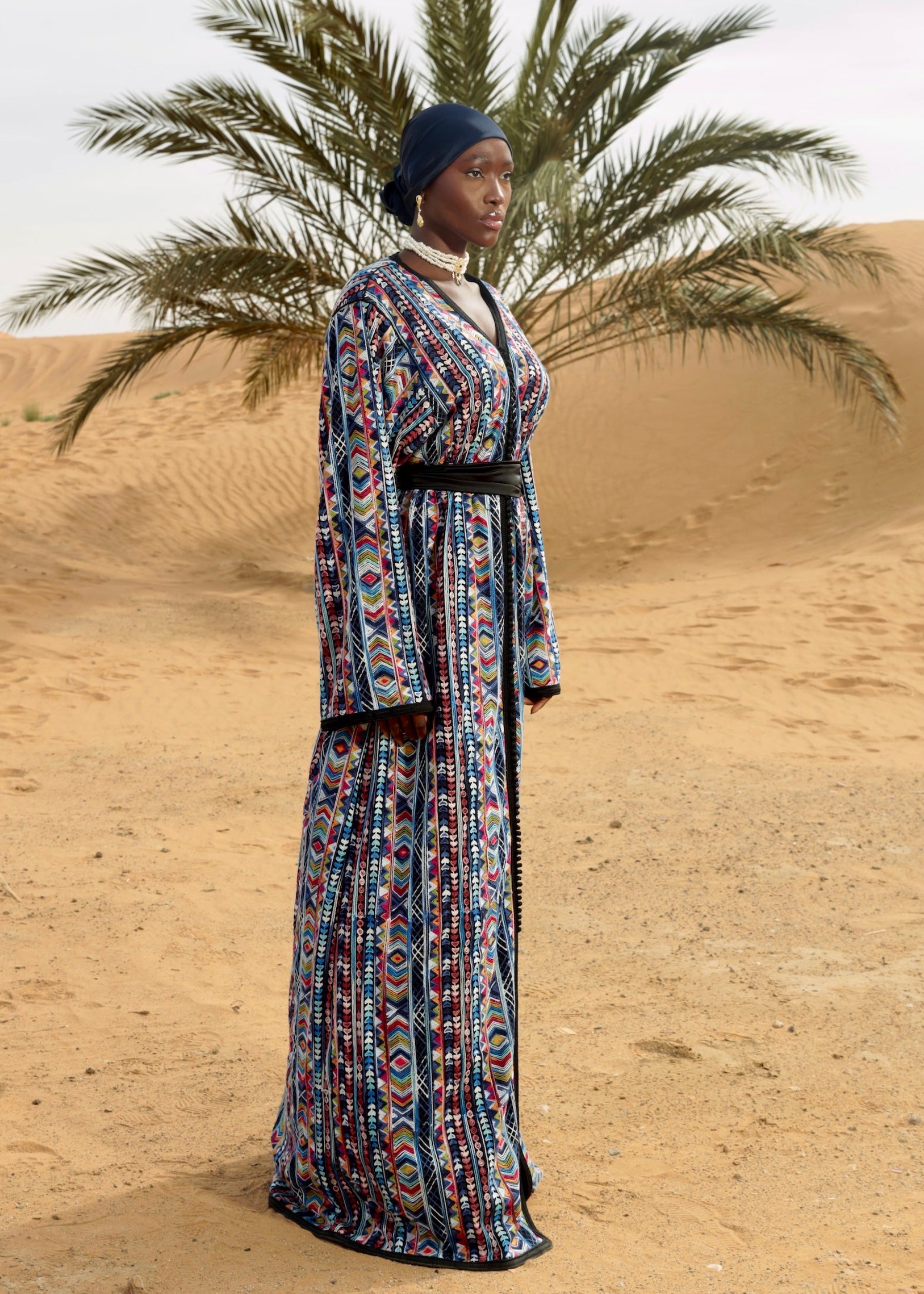 Caftan en tulle noir avec broderies multicolores et sfifa artisanale, vue de profil.
