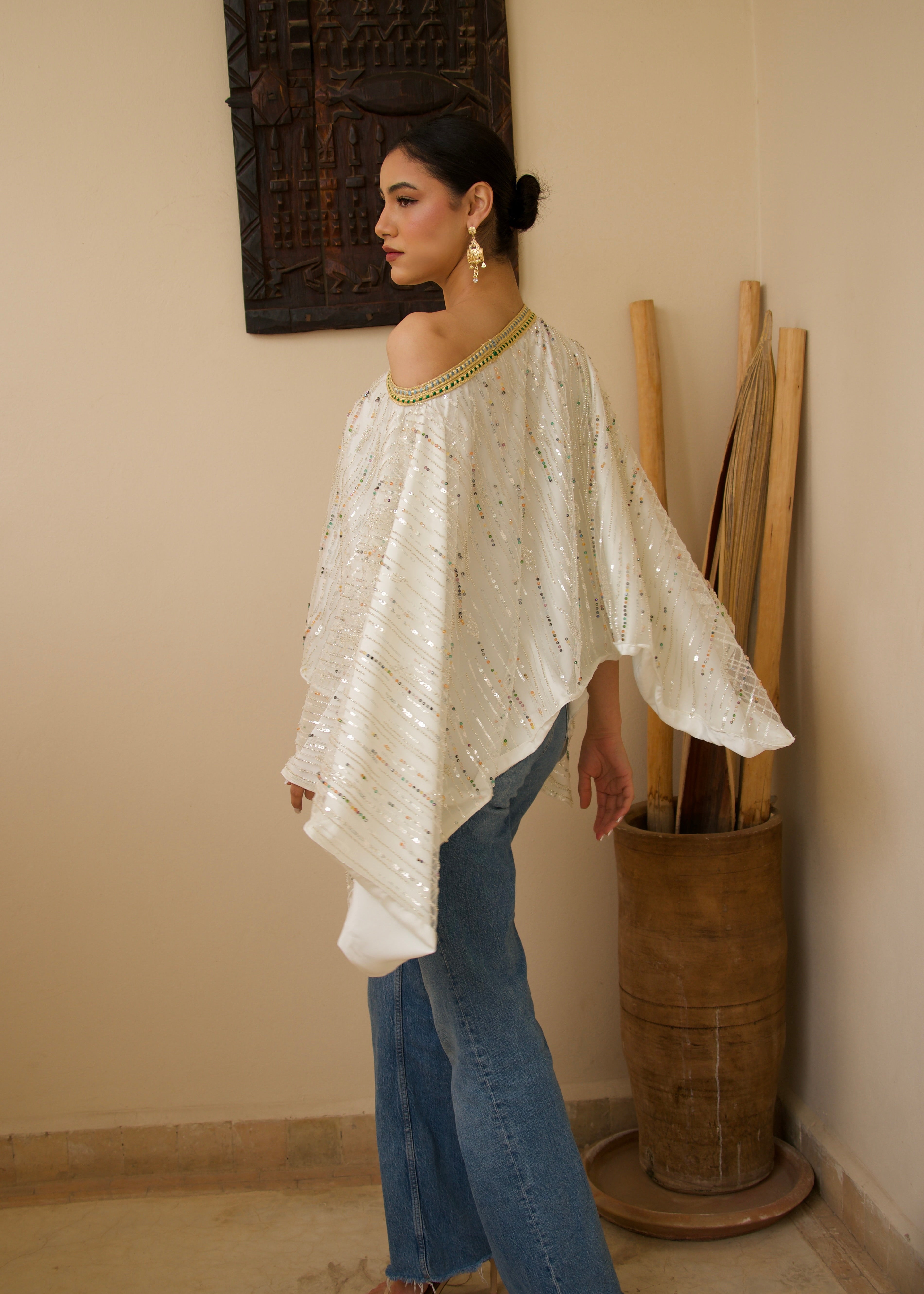 White flowing tulle cape with decorative pearls, seen from the back.