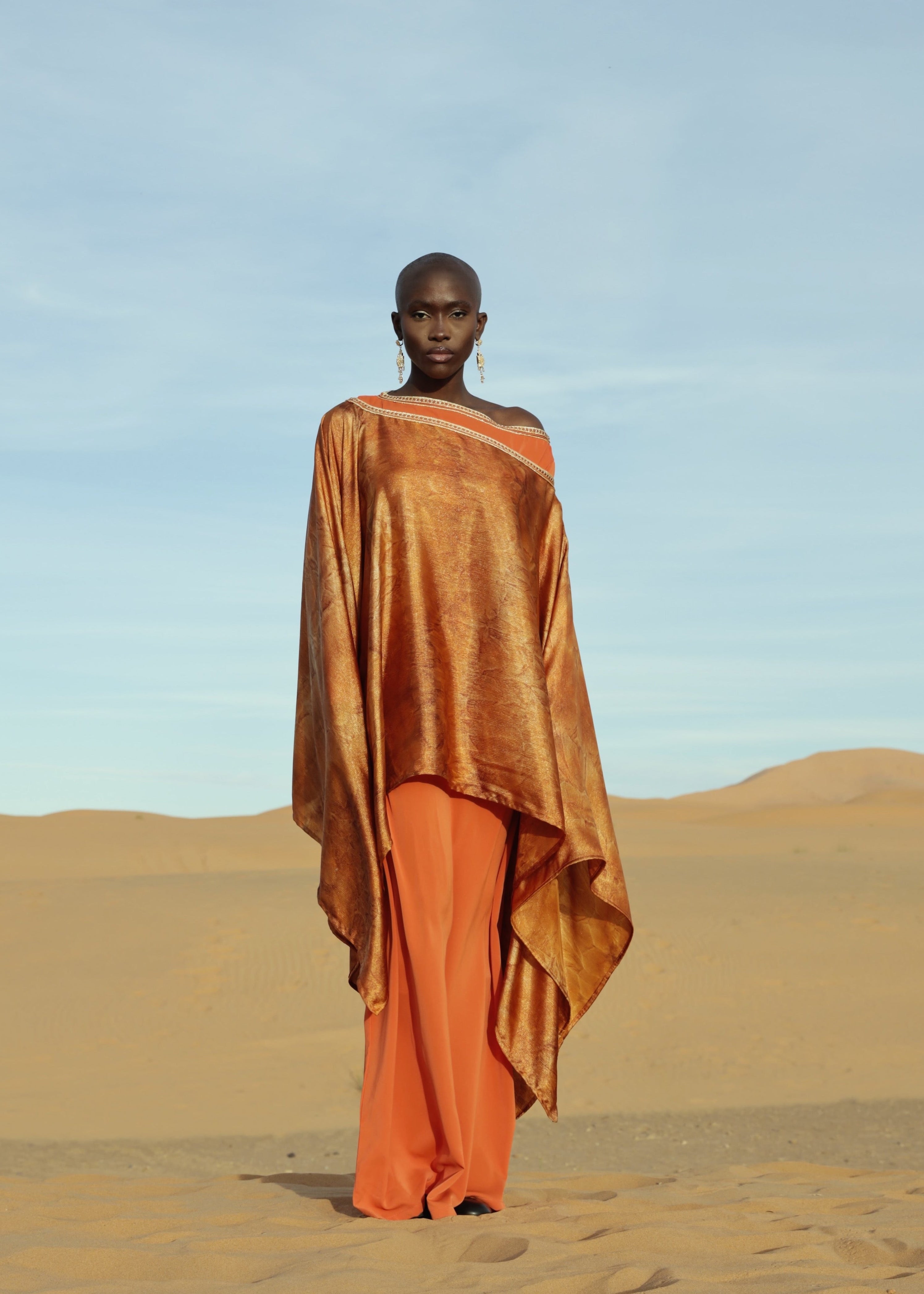 Orange cape made of lamé silk with shimmering highlights, viewed from the front.