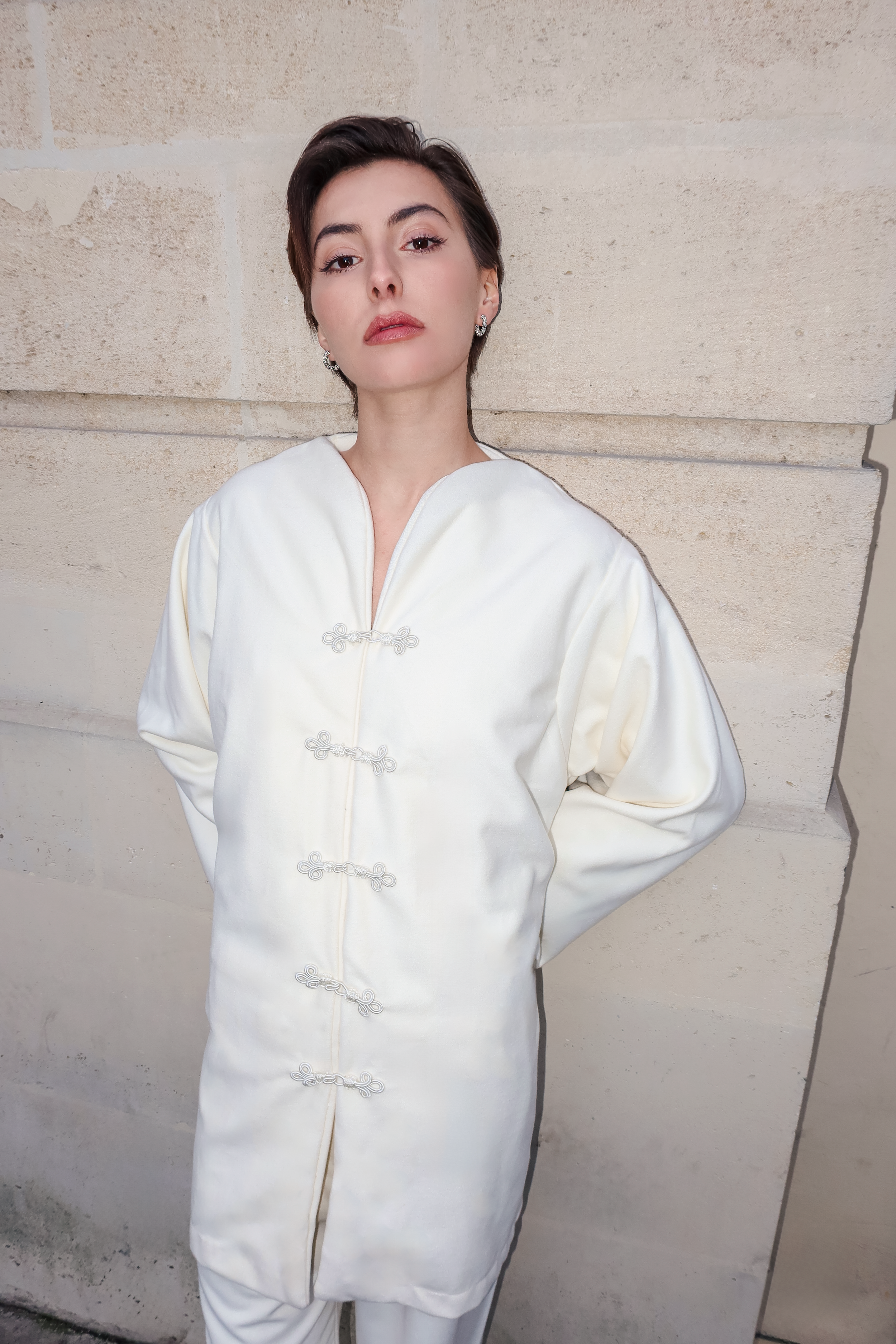 Gros plan sur les boutons marocains artisanaux d’un ensemble en cachemire beige