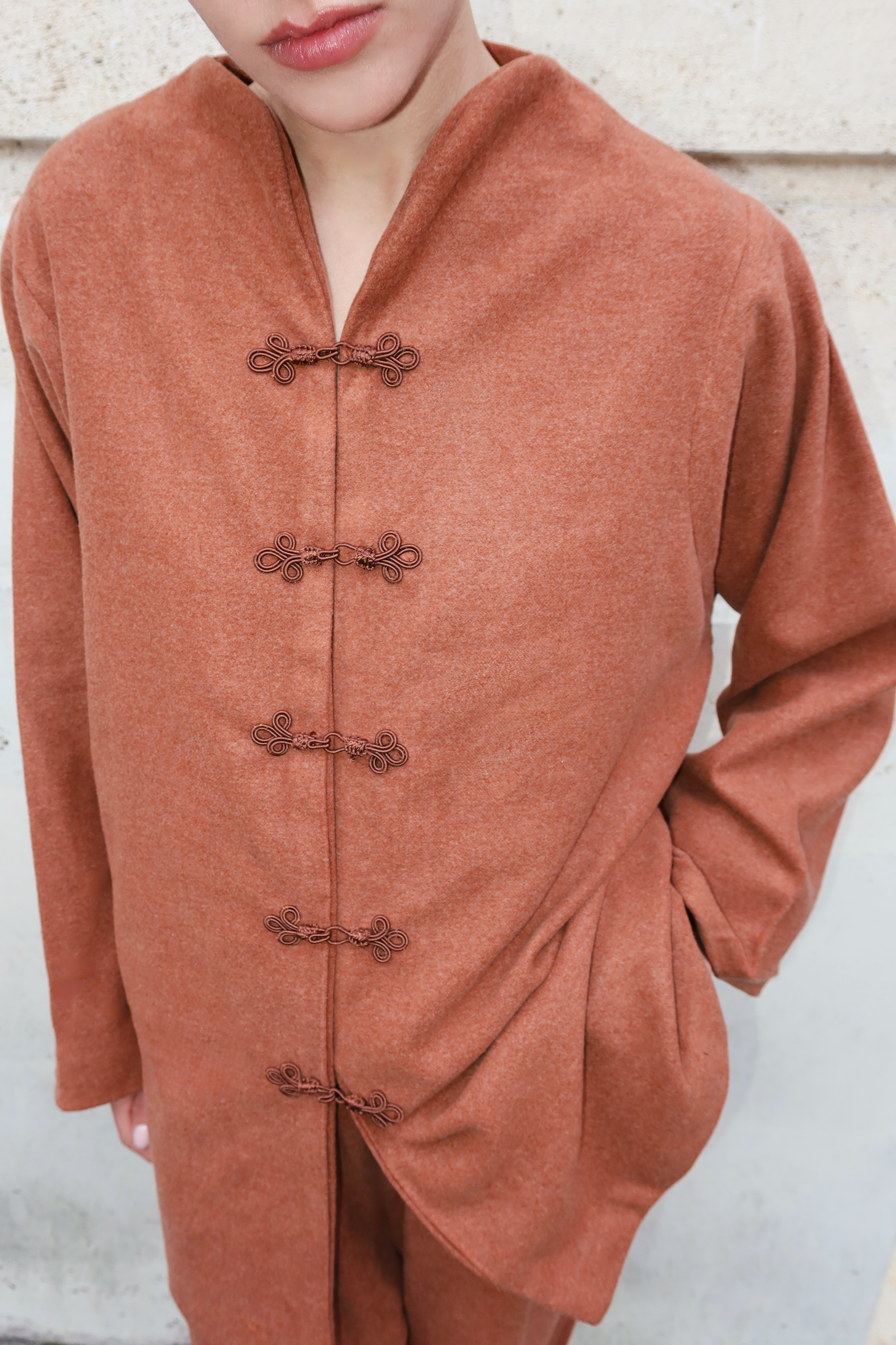 Gros plan sur les boutons marocains artisanaux d’un ensemble en cachemire marron