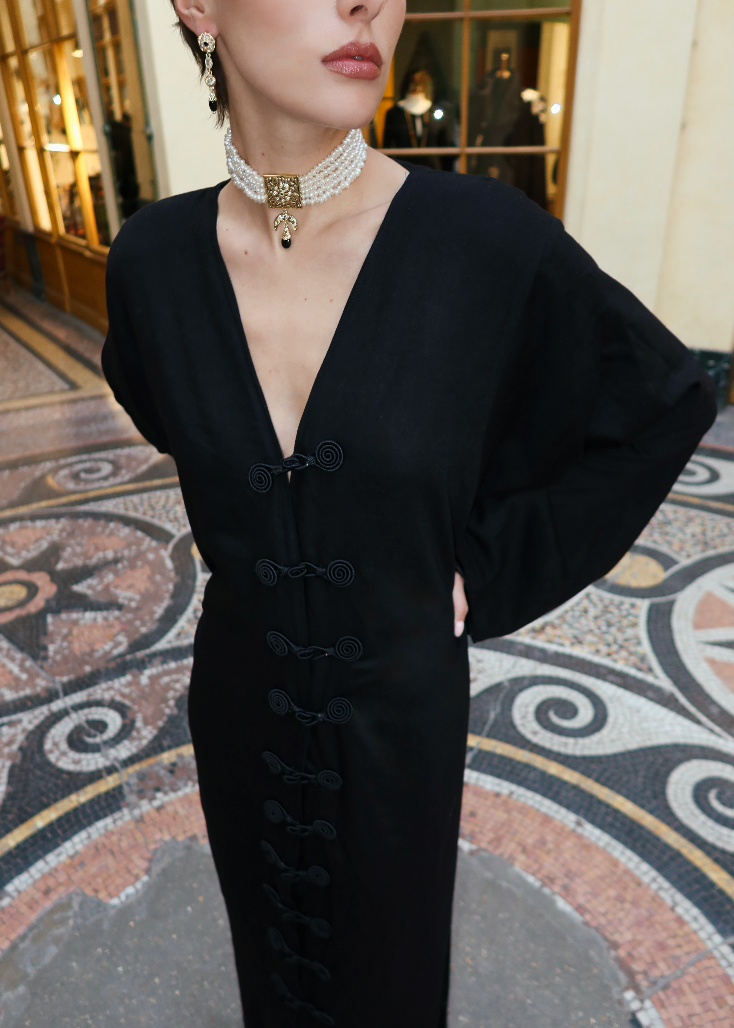 Gros plan sur les crochets marocains artisanaux d’une robe en soie Mlifa noire