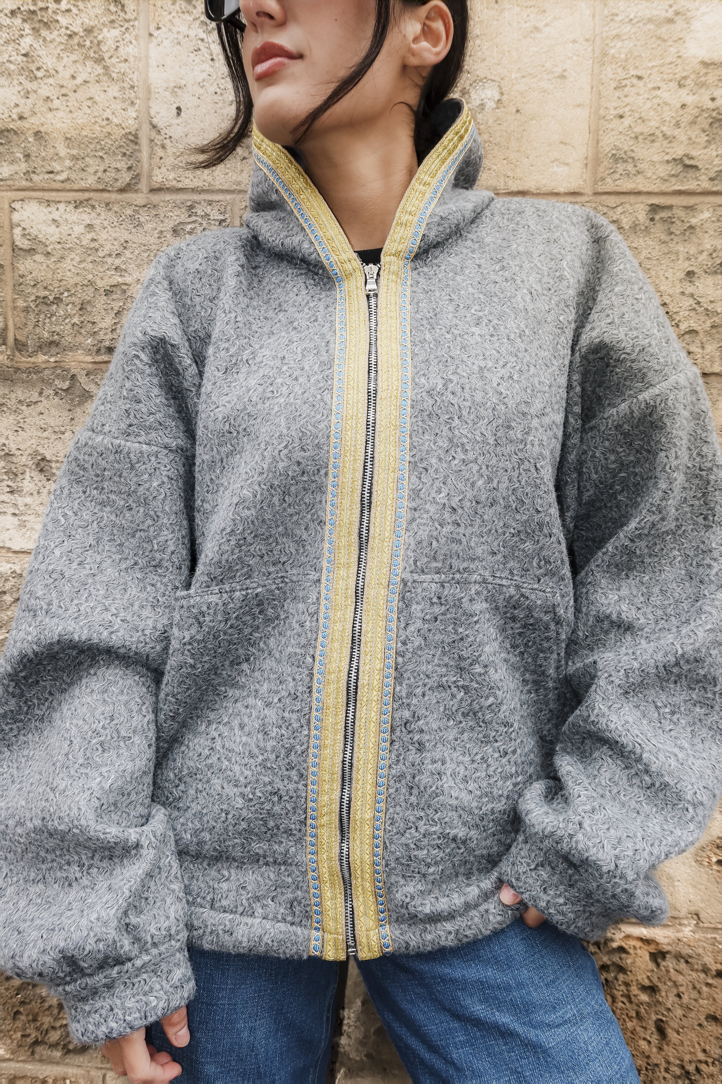 Détail de la sfifa marocaine verte et bleue sur sweat gilet en laine bouclée grise