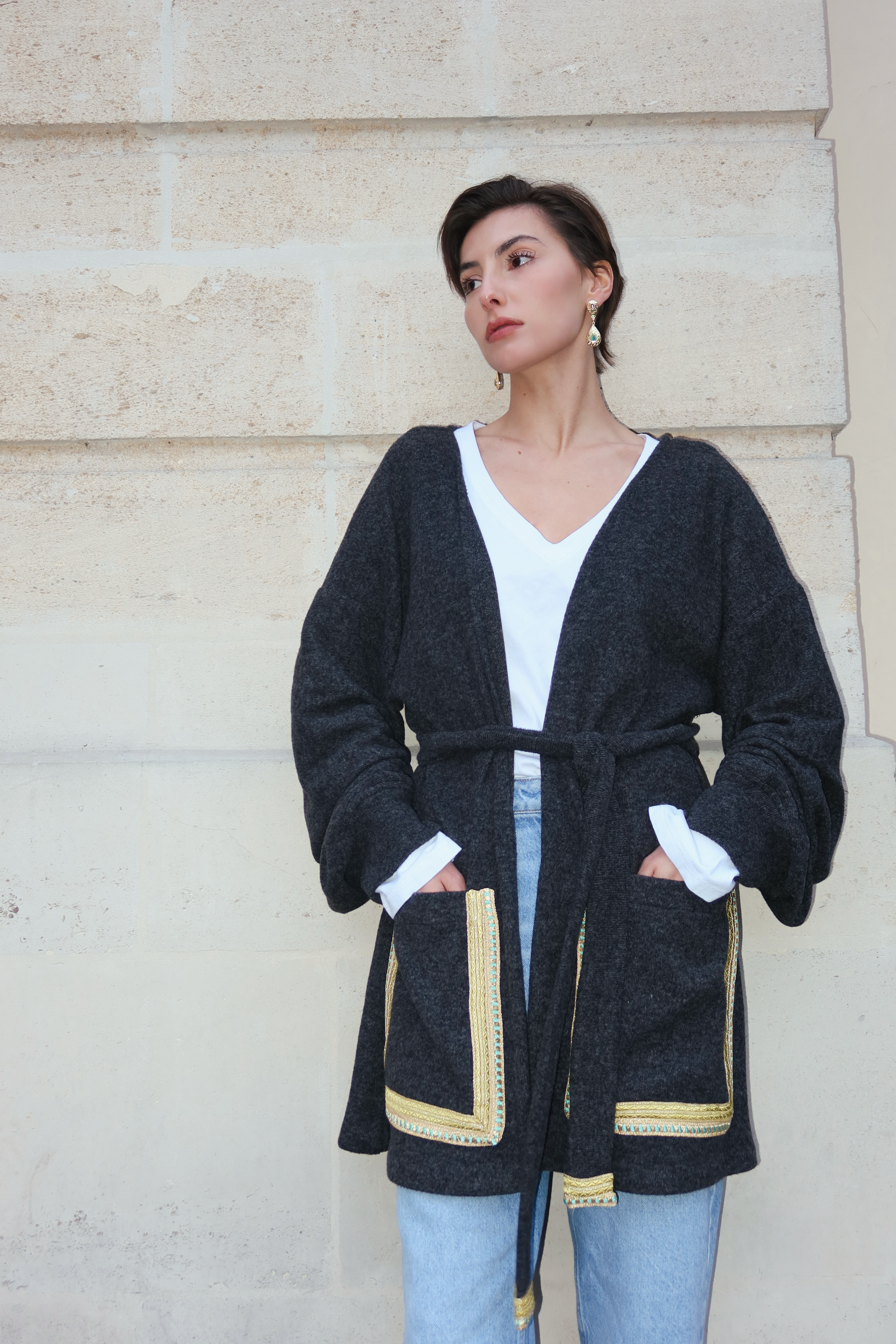 Gilet en laine gris foncé en mouvement révélant un tombé naturel et un détail sfifa élégant