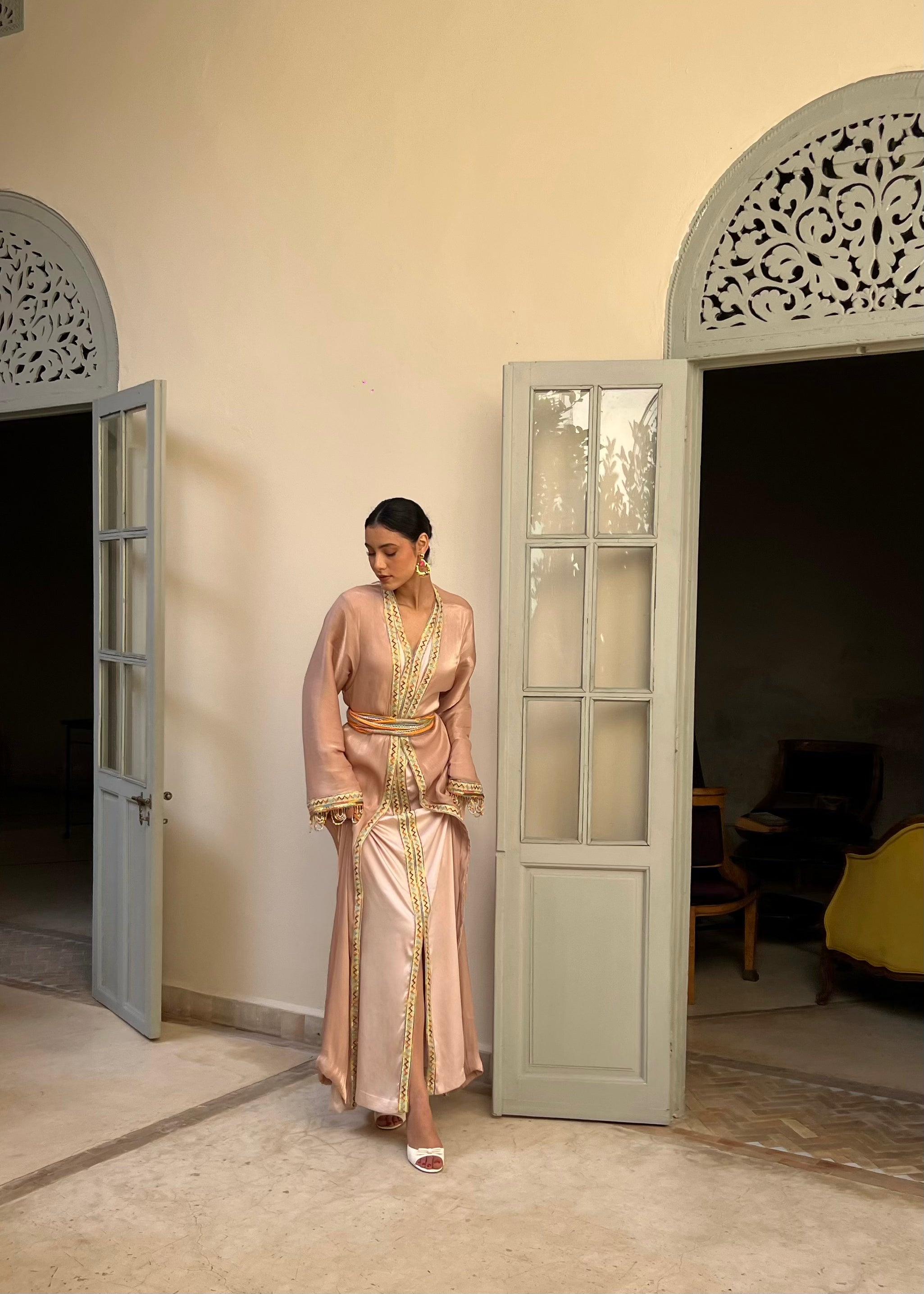 Profil du caftan kabyle rose en organza brodé, manches perlées et ceinture en laine colorée