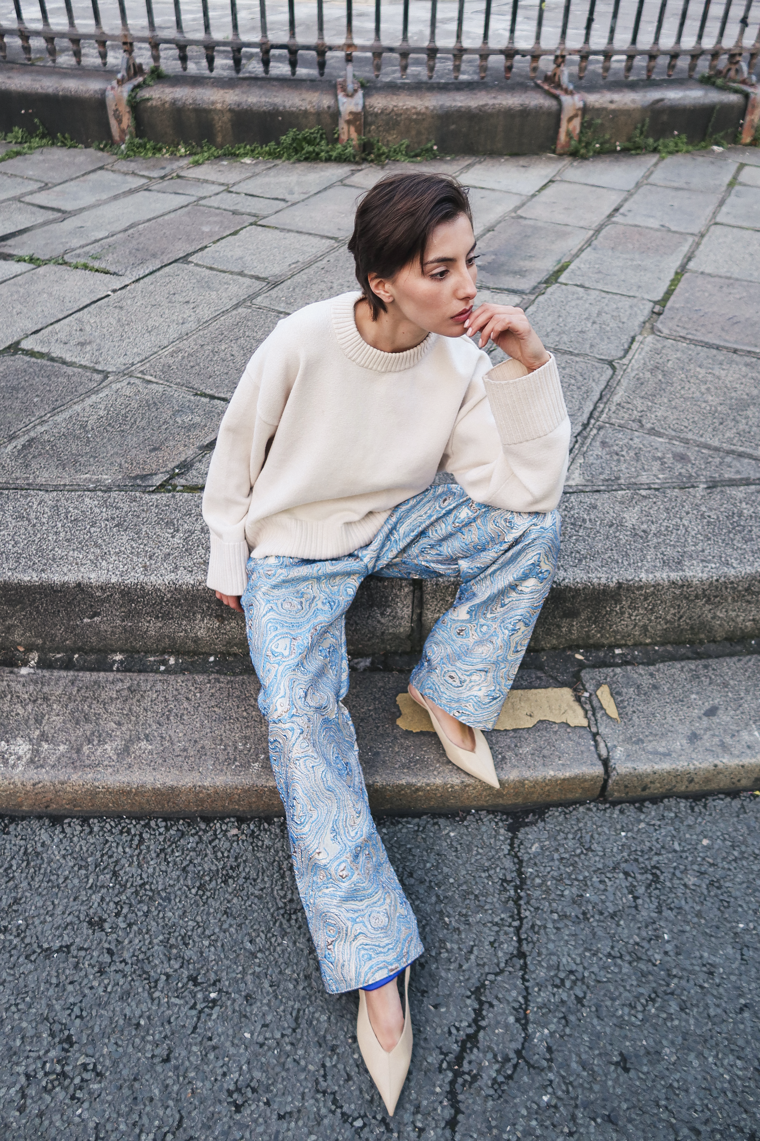 Pantalon en brocard bleu en mouvement révélant la fluidité du tissu et une coupe droite