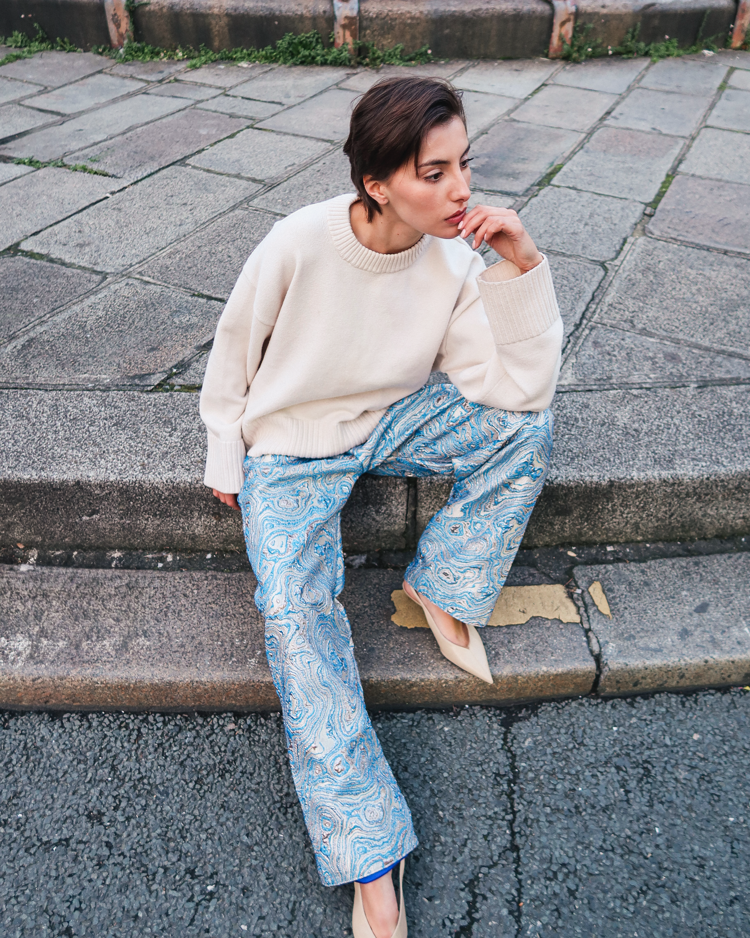 Pantalon en brocard bleu en mouvement révélant la fluidité du tissu et une coupe droite