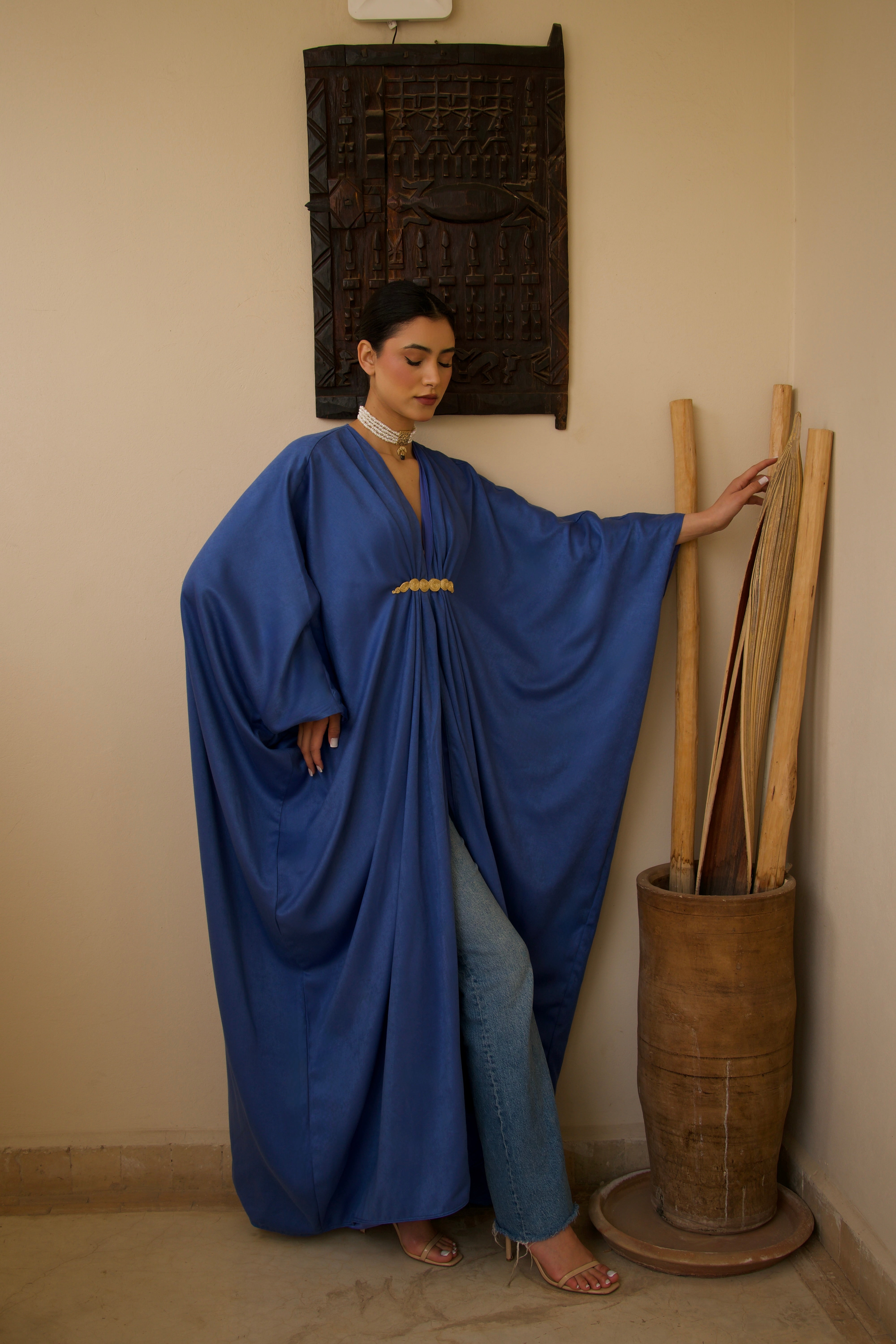 Robe longue bleue en soie mlifa avec drapé élégant et broche marocaine, vue de face.