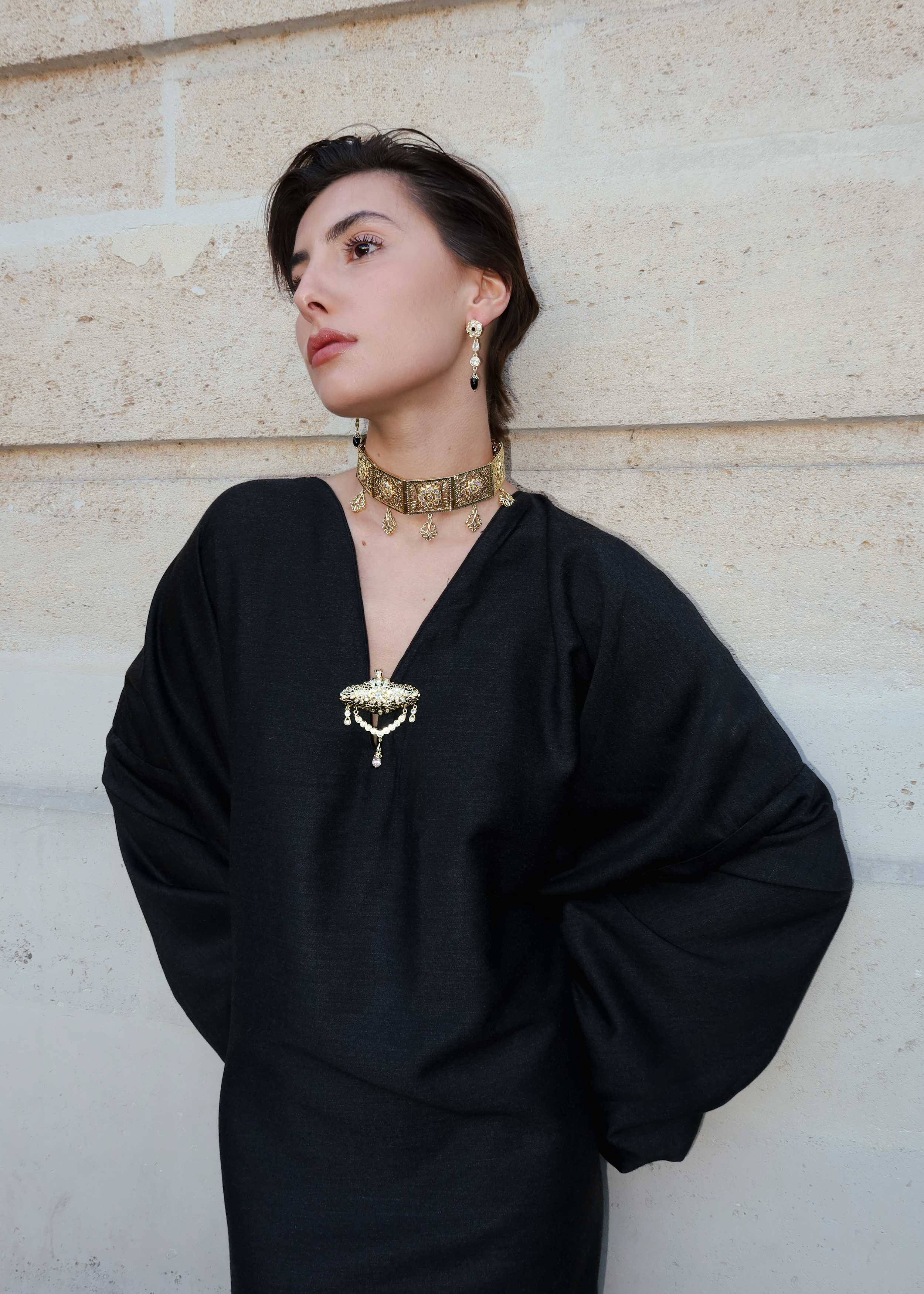 Robe traditionnelle en soie Mlifa grise portée de face, ornée d’une élégante broche marocaine artisanale