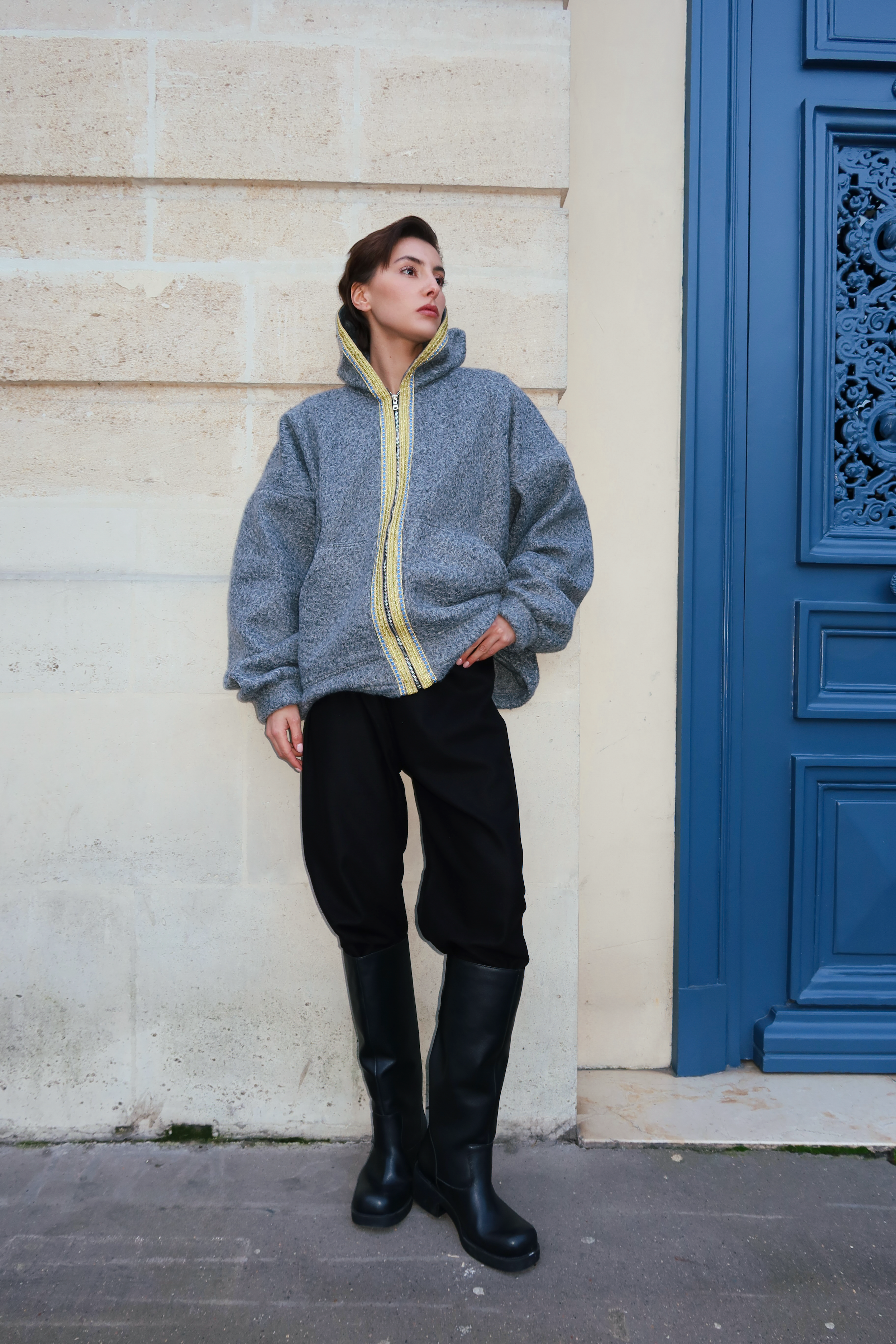 Sweat en laine bouclée grise porté de face, orné d’une sfifa d’inspiration marocaine