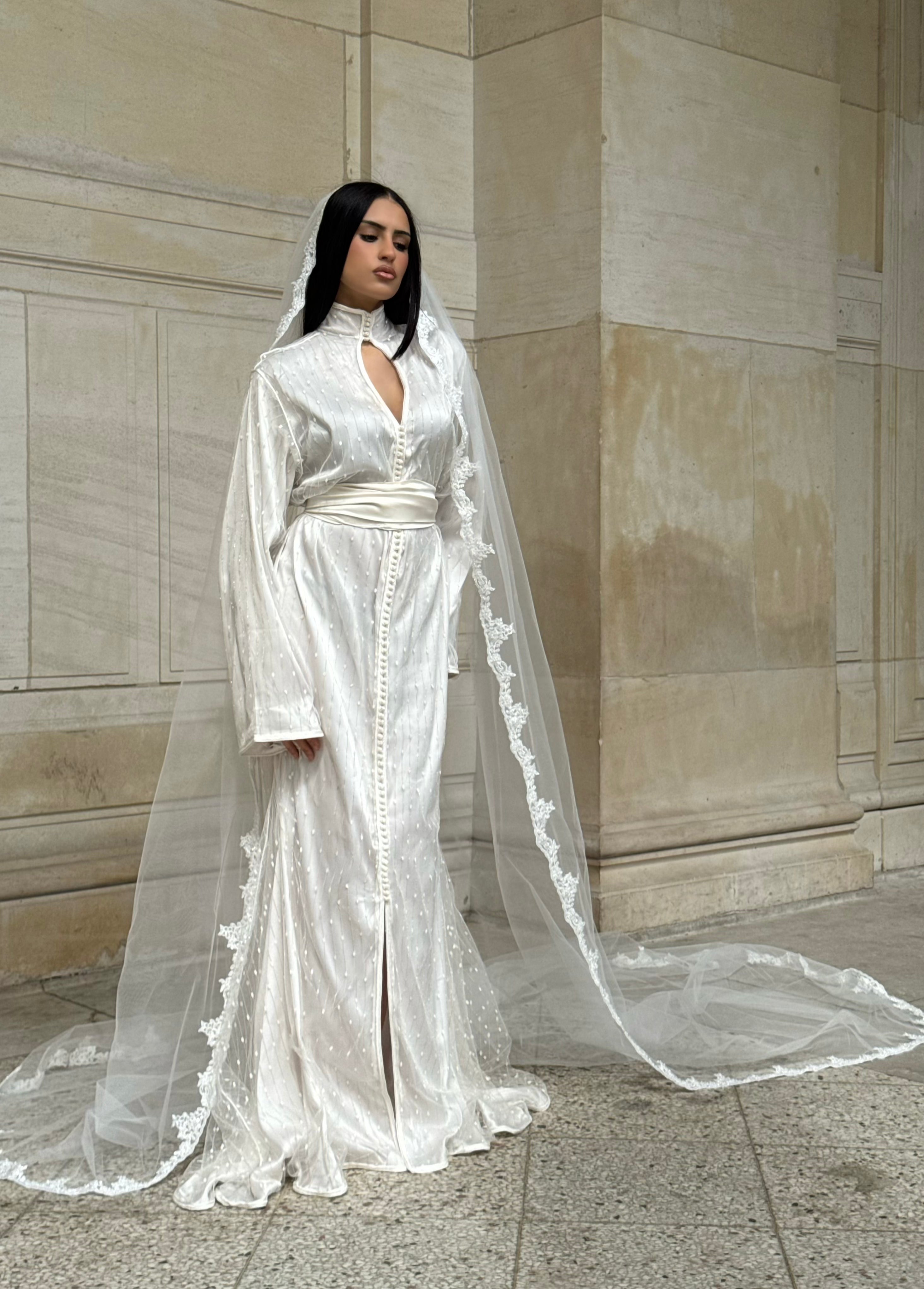 White Kaftan with a high neckline and a veil worn as a stylish accessory