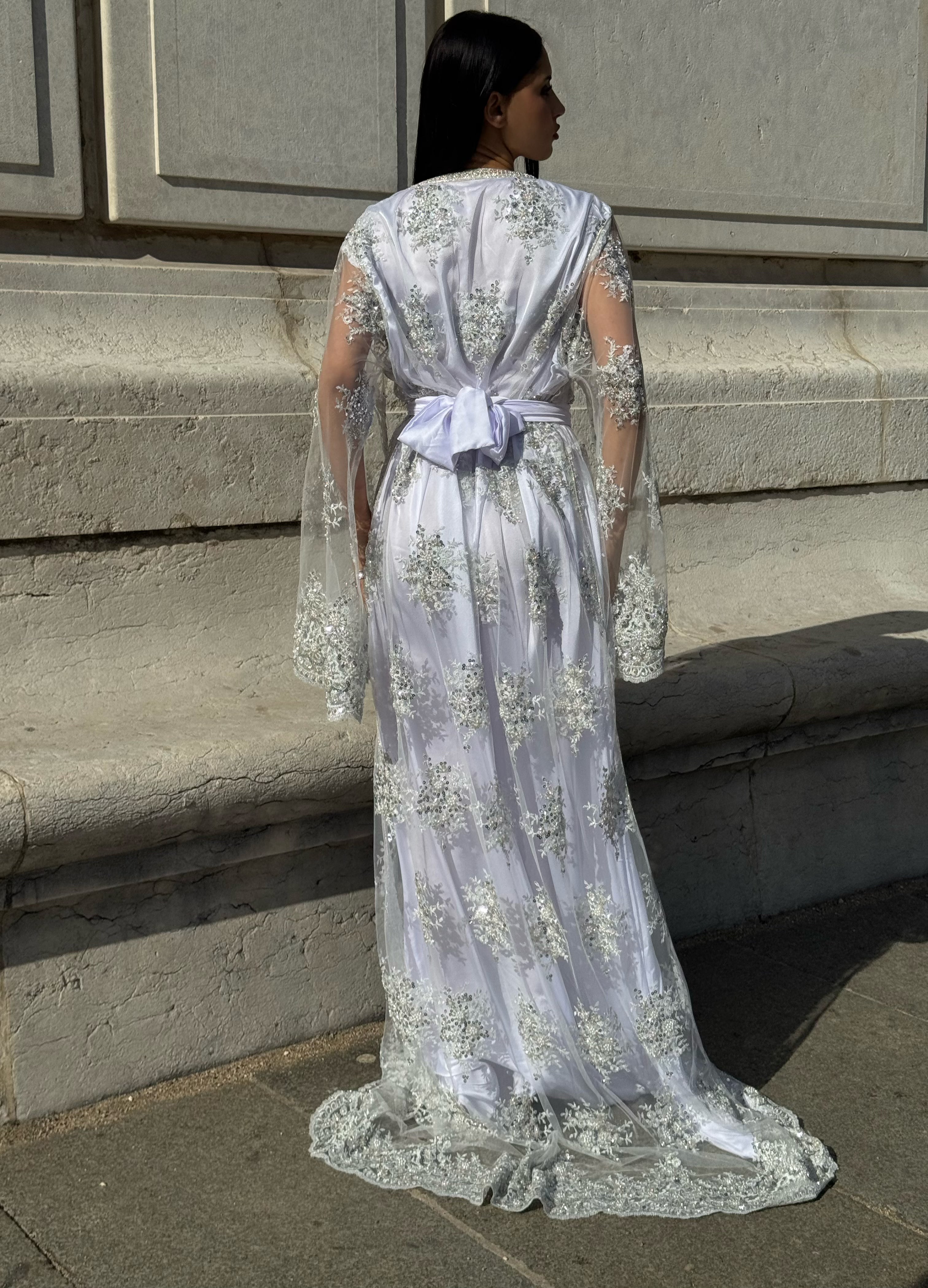 Vue de dos du caftan de mariée blanc à ornements argentés avec ceinture blanche