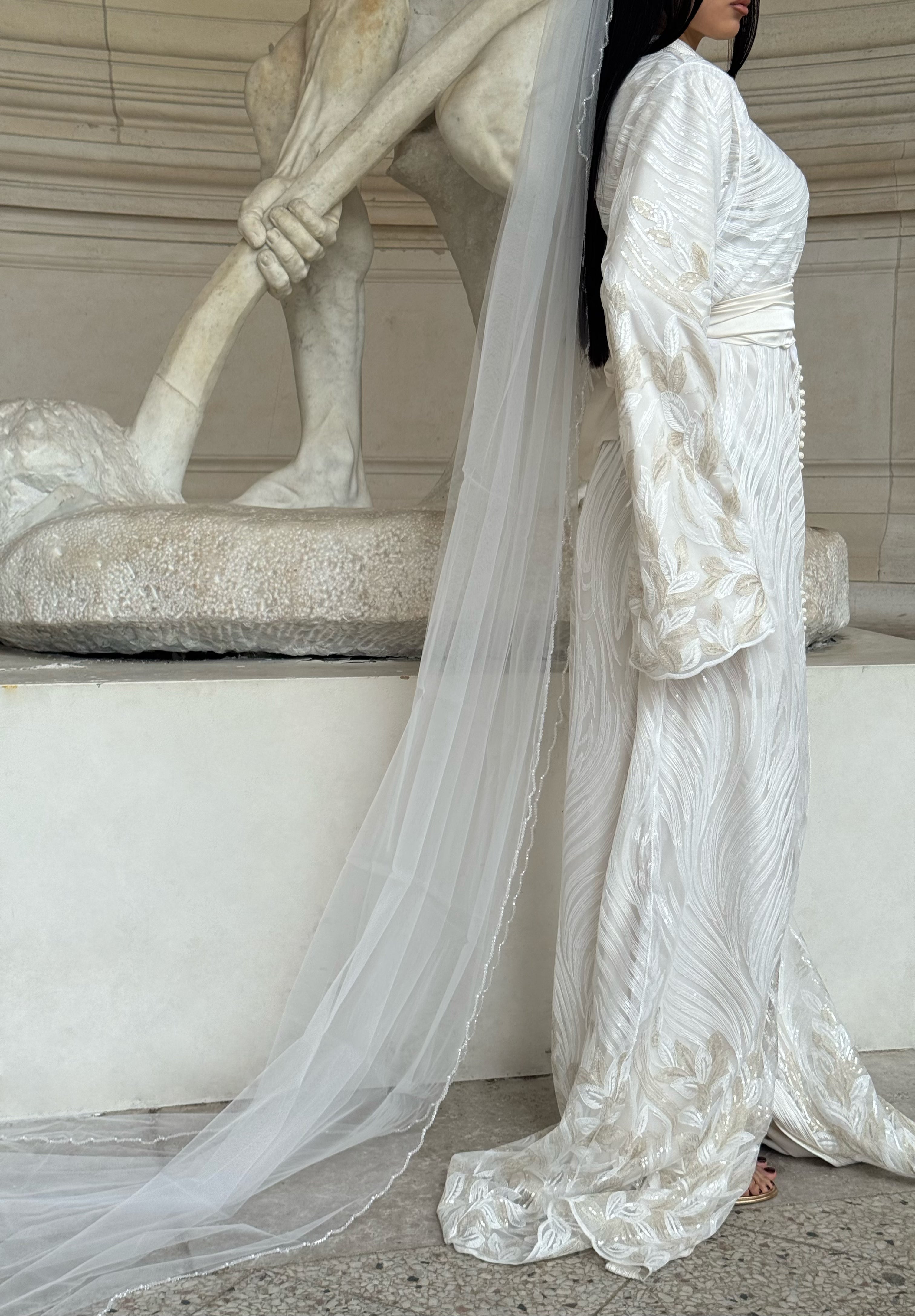 Close-up of the silhouette and textured fabric on a white Kaftan