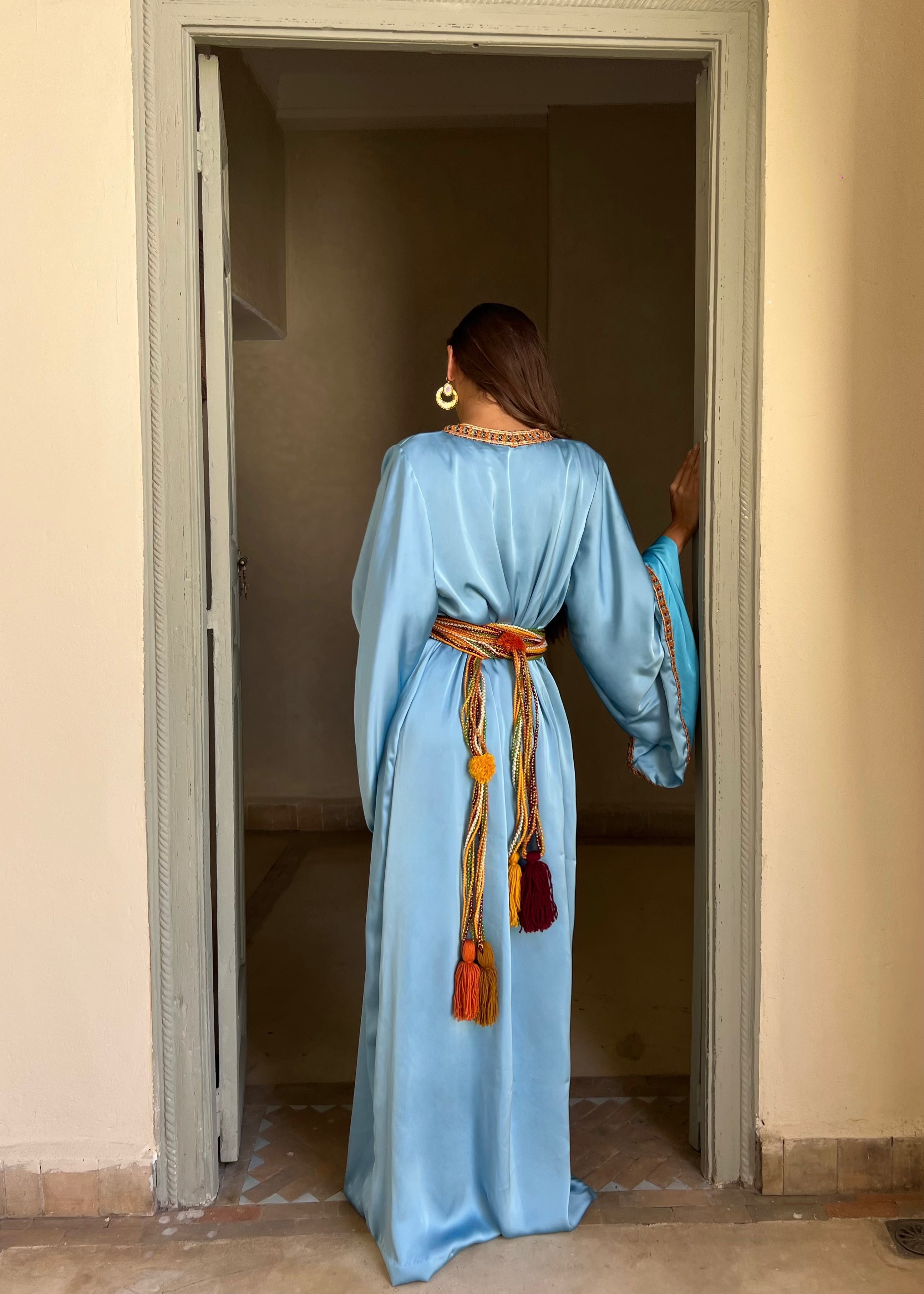 Back of the Kabyle Kaftan in blue silk cloth, fine embroidery and fluid fall of the satin fabric.