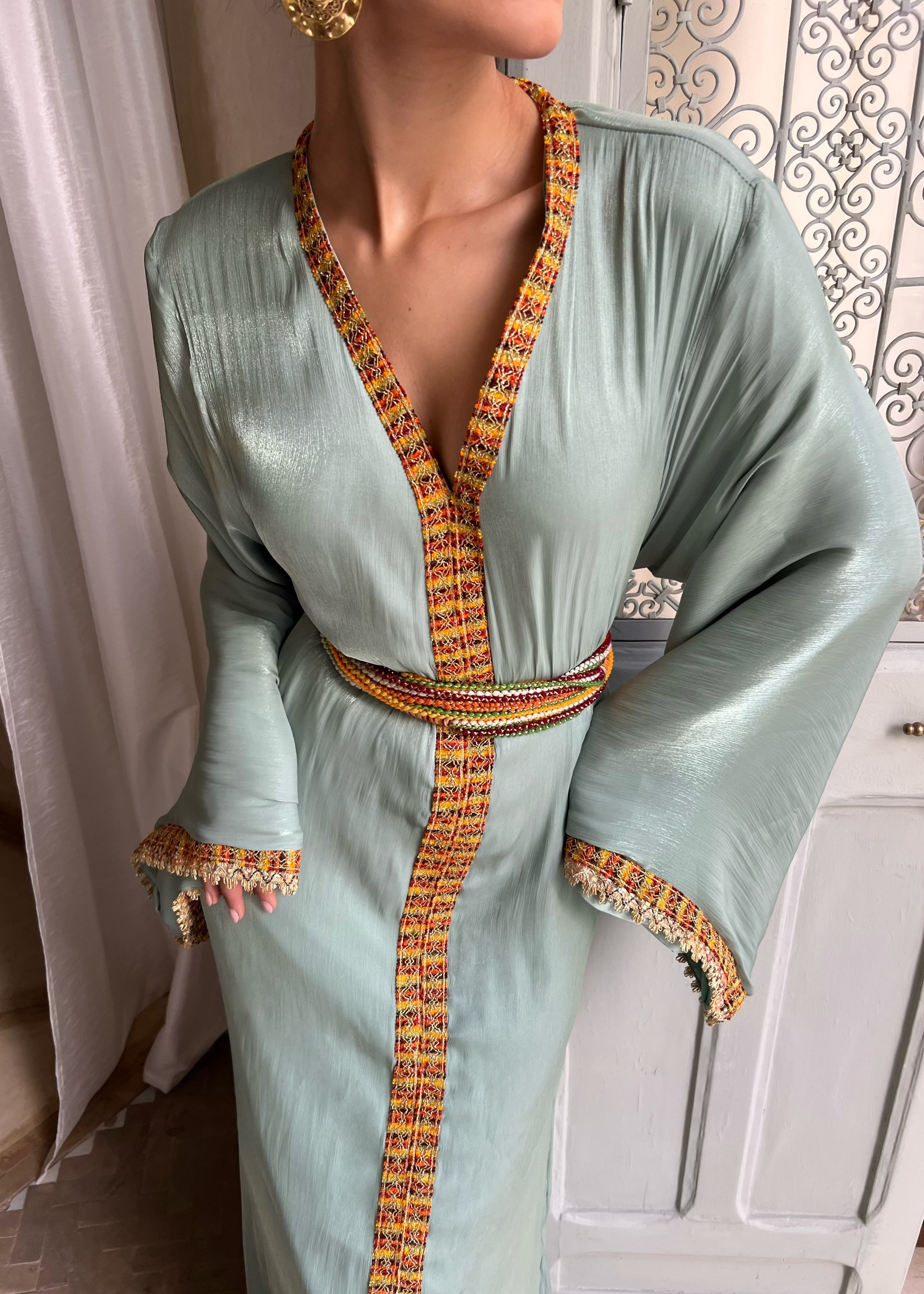 Caftan kabyle en organza vert clair avec ceinture en laine, broderies fines et coupe traditionnelle, vue de face sur mannequin