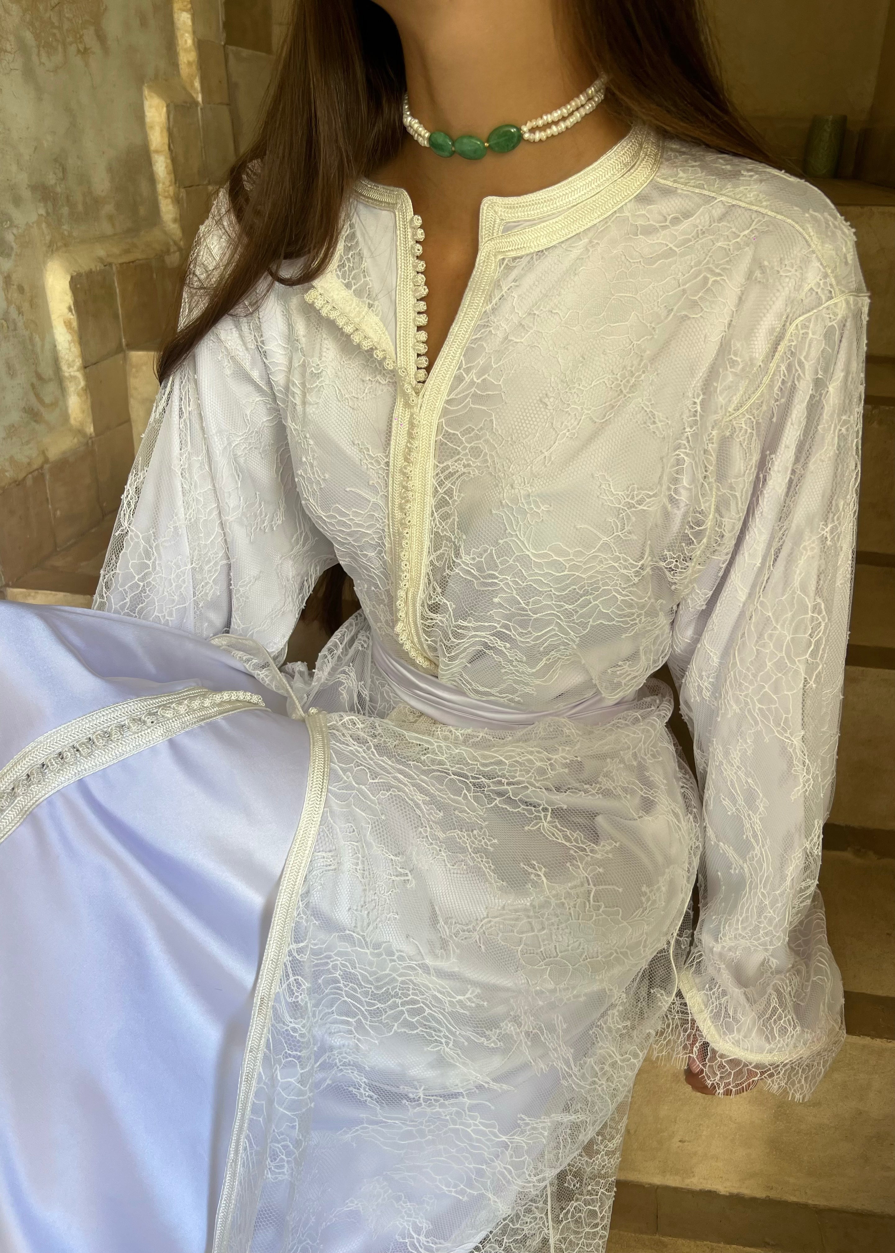 Caftan de mariée en dentelle de Calais blanc, vue assise élégante mettant en valeur la fluidité du tissu