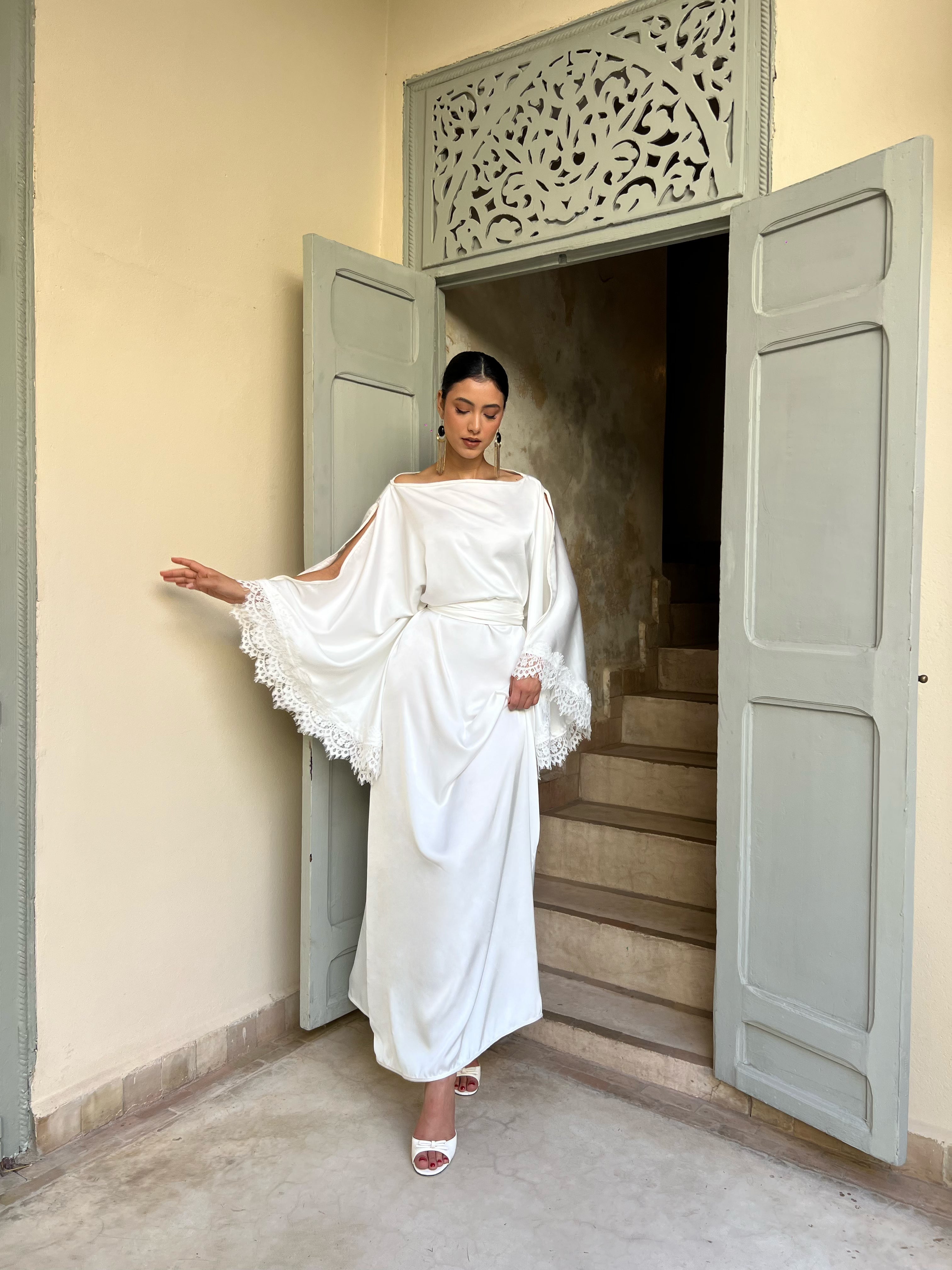 Caftan de mariée en drap de soie blanc avec manches ange en mouvement, tissu fluide et élégance aérienne