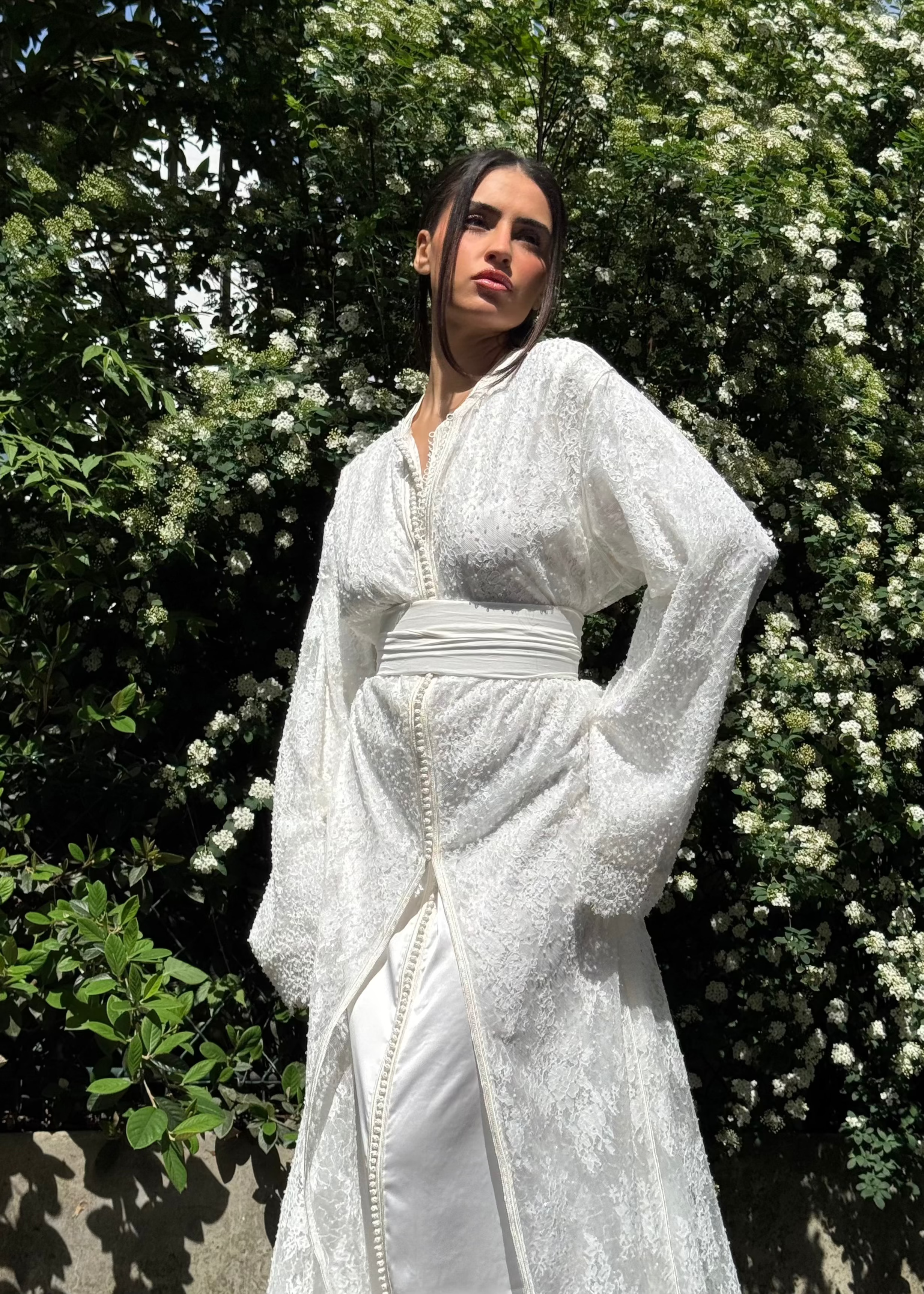 Caftan de mariée en tulle perlé capturé en mouvement, mettant en valeur la fluidité du tissu et la brillance délicate des perles.