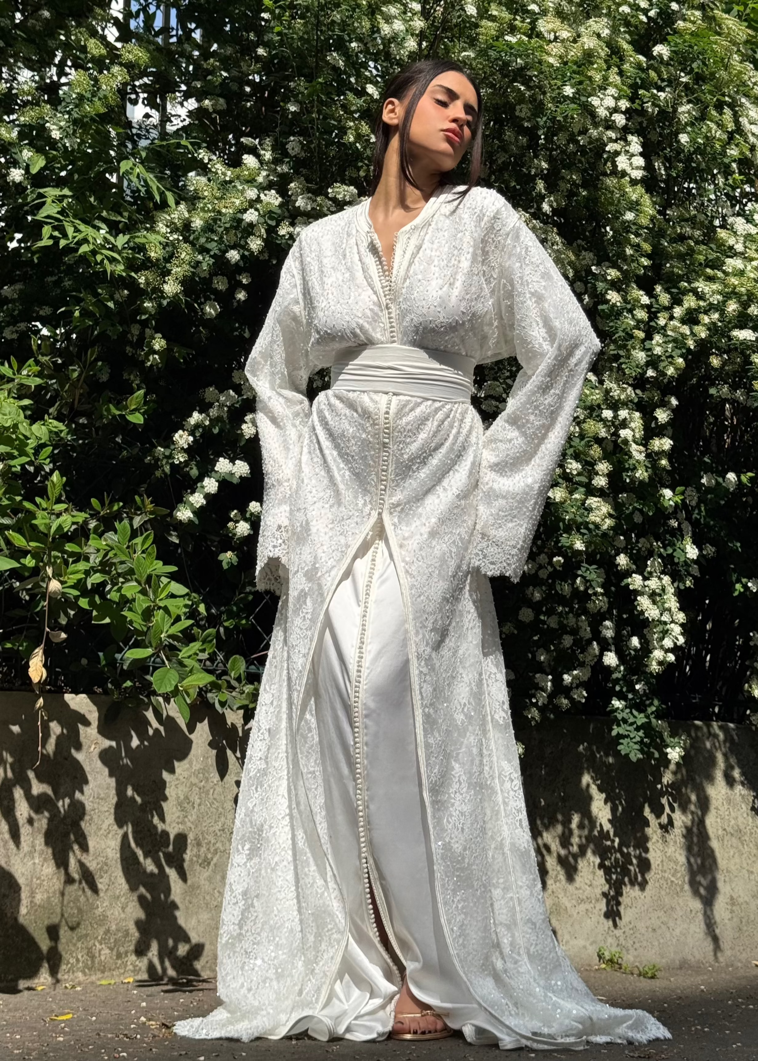 Caftan de mariée en tulle perlé vu de profil, soulignant la légèreté du tulle et l’éclat subtil des perles.