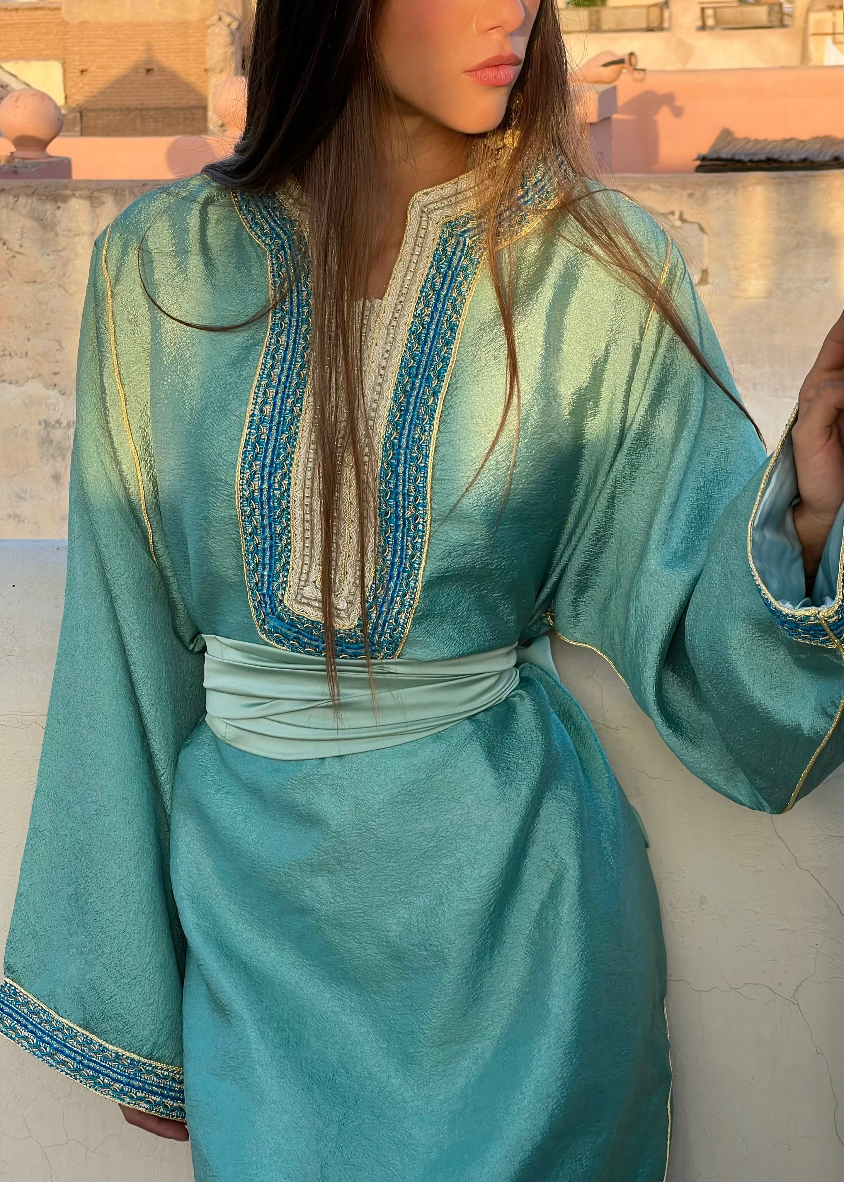 Caftan moderne en satin vert d’eau en mouvement, effet fluide du drapé et reflets brillants du satin