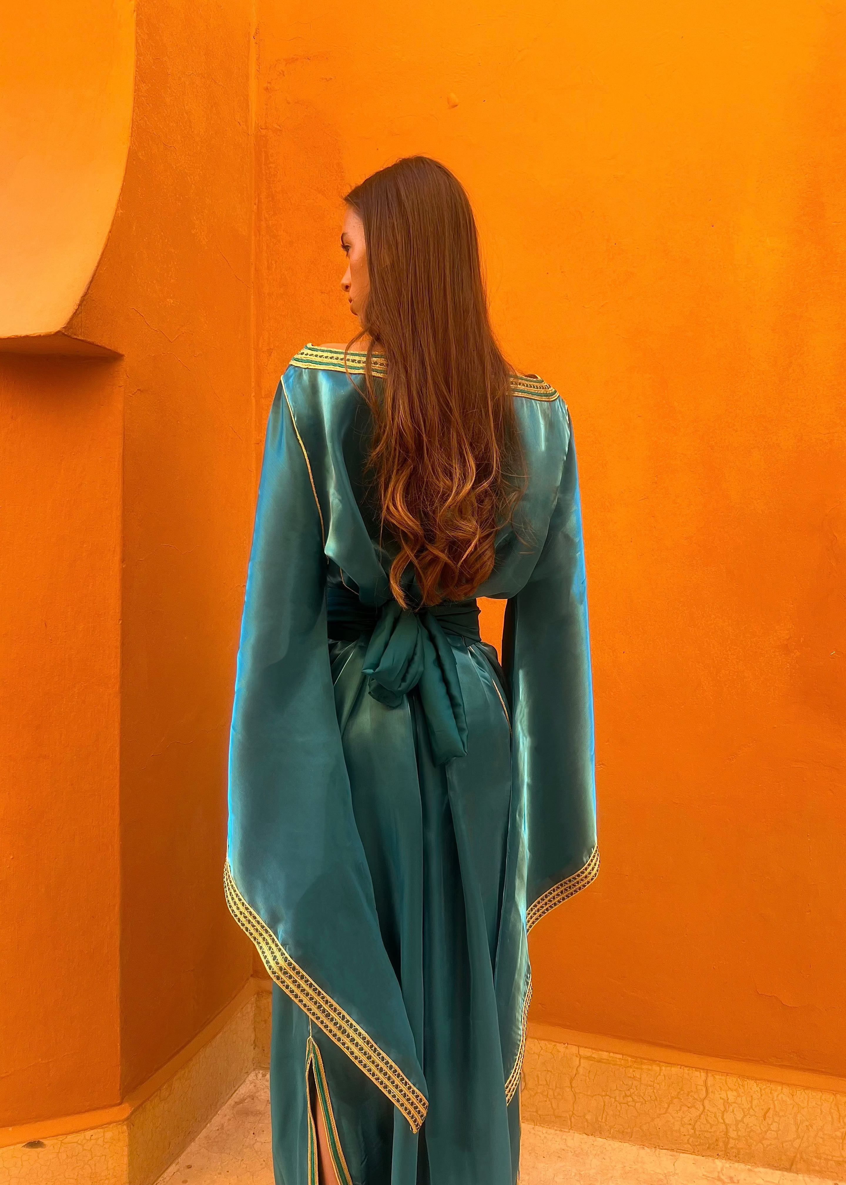 Caftan en organza bleu saphir à manches évasées vu de dos, soulignant la légèreté du tissu et la transparence élégante de l’organza.