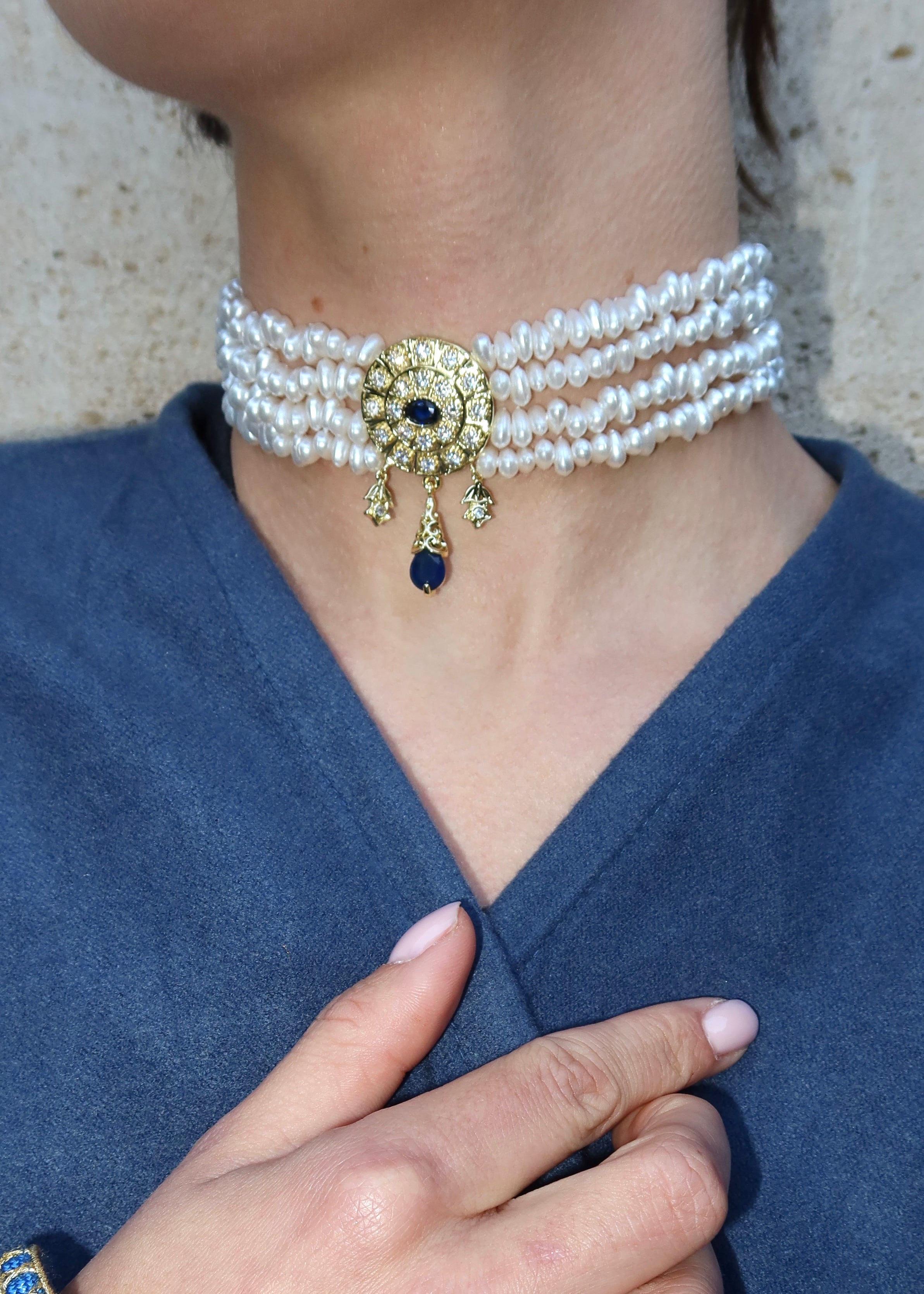 Détail choker perlé ivoire avec pierre bleue