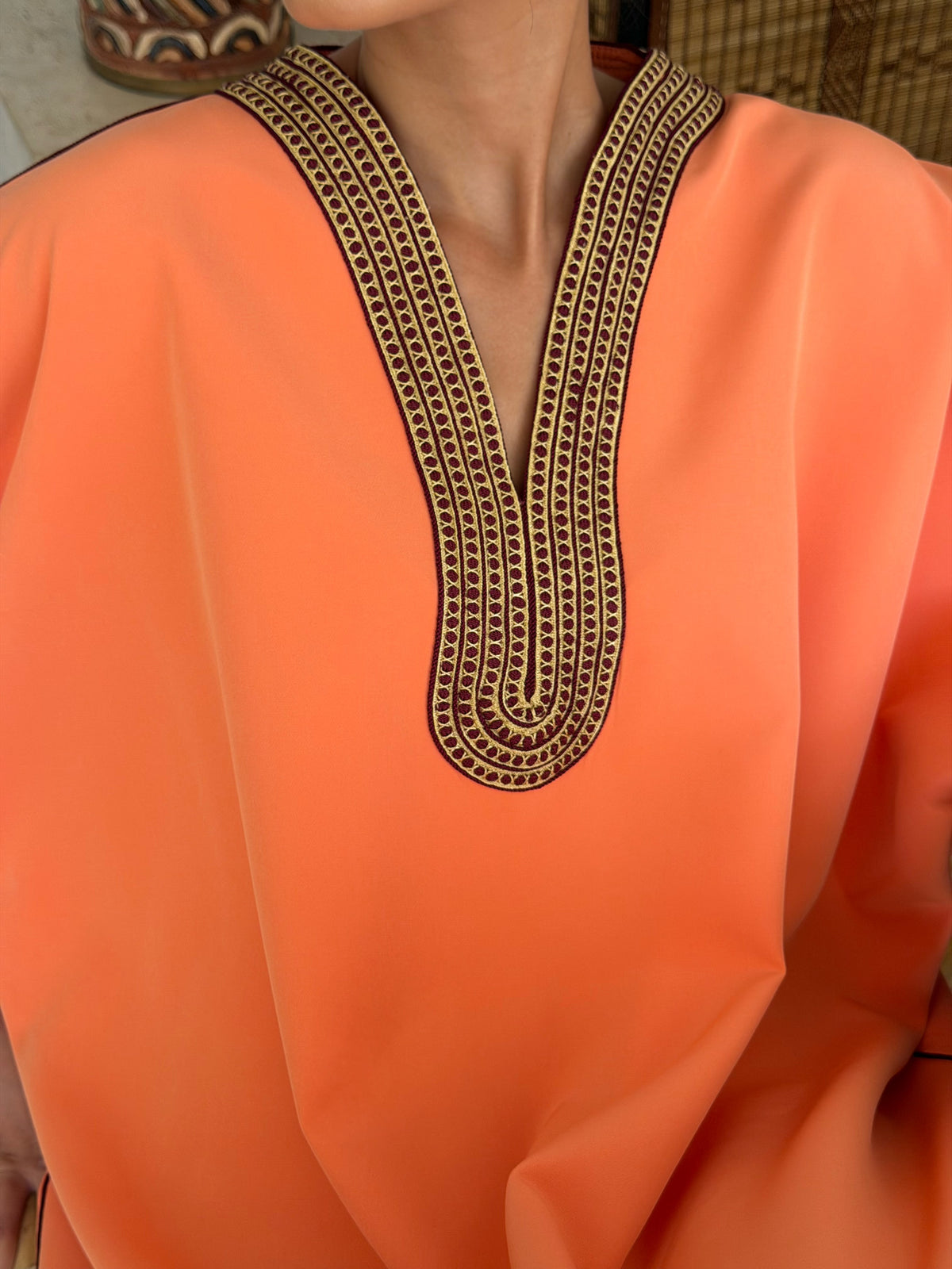 Robe Longue Corail aux Finitions Bordeaux — Détail de l’encolure contrastée.