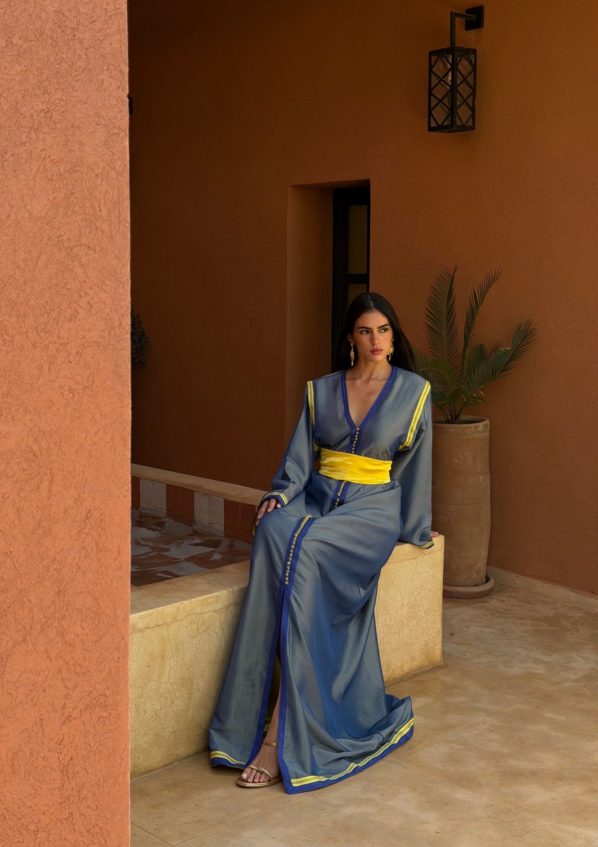 Caftan Bleu Ardoise à Ceinture Jaune — Vue assise montrant le tombé et les manches.