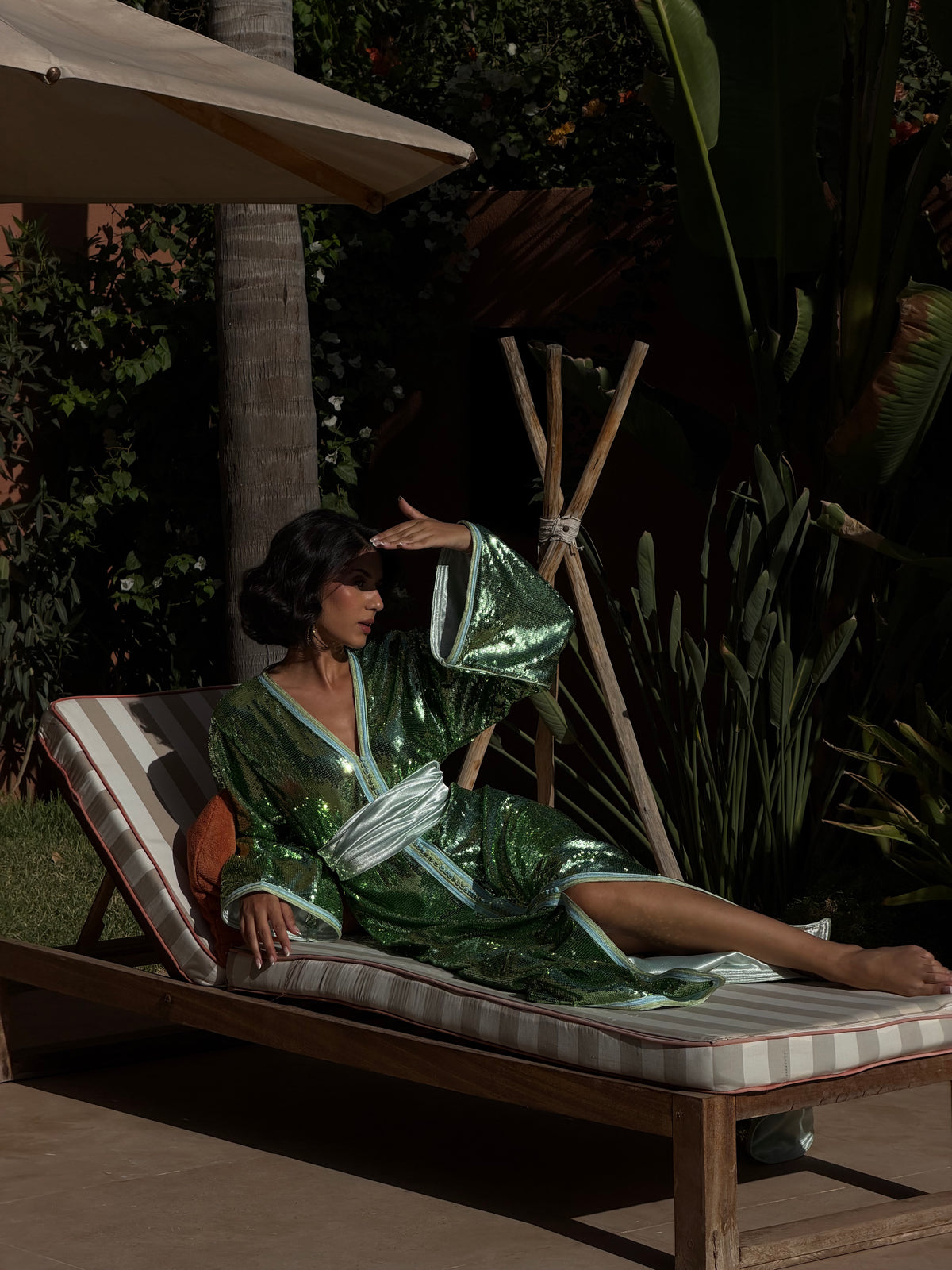 Caftan vert à sequins, modèle sur une chaise longue