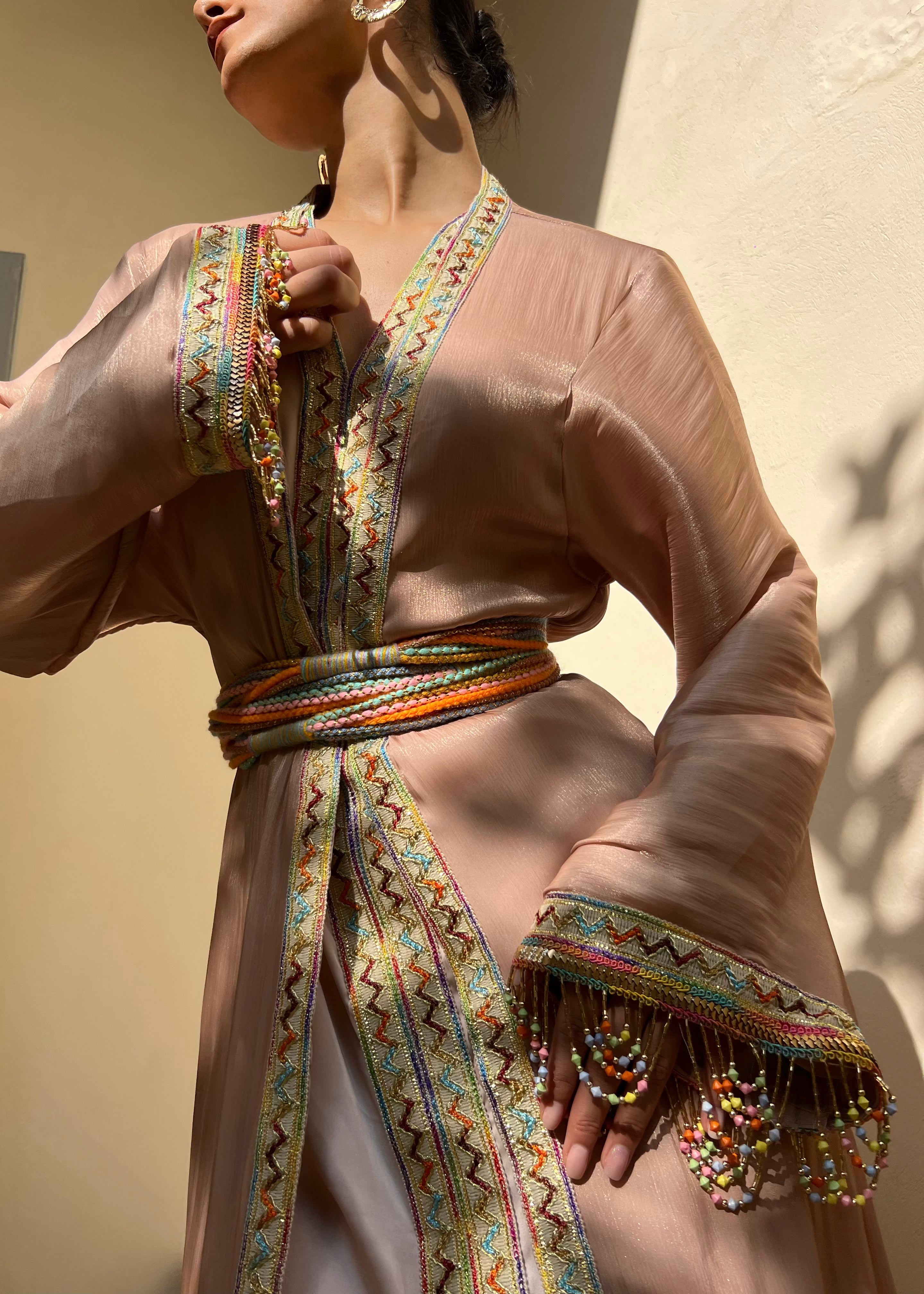 Détail du caftan kabyle rose en organza, broderie artisanale, manches perlées et ceinture en laine traditionnelle
