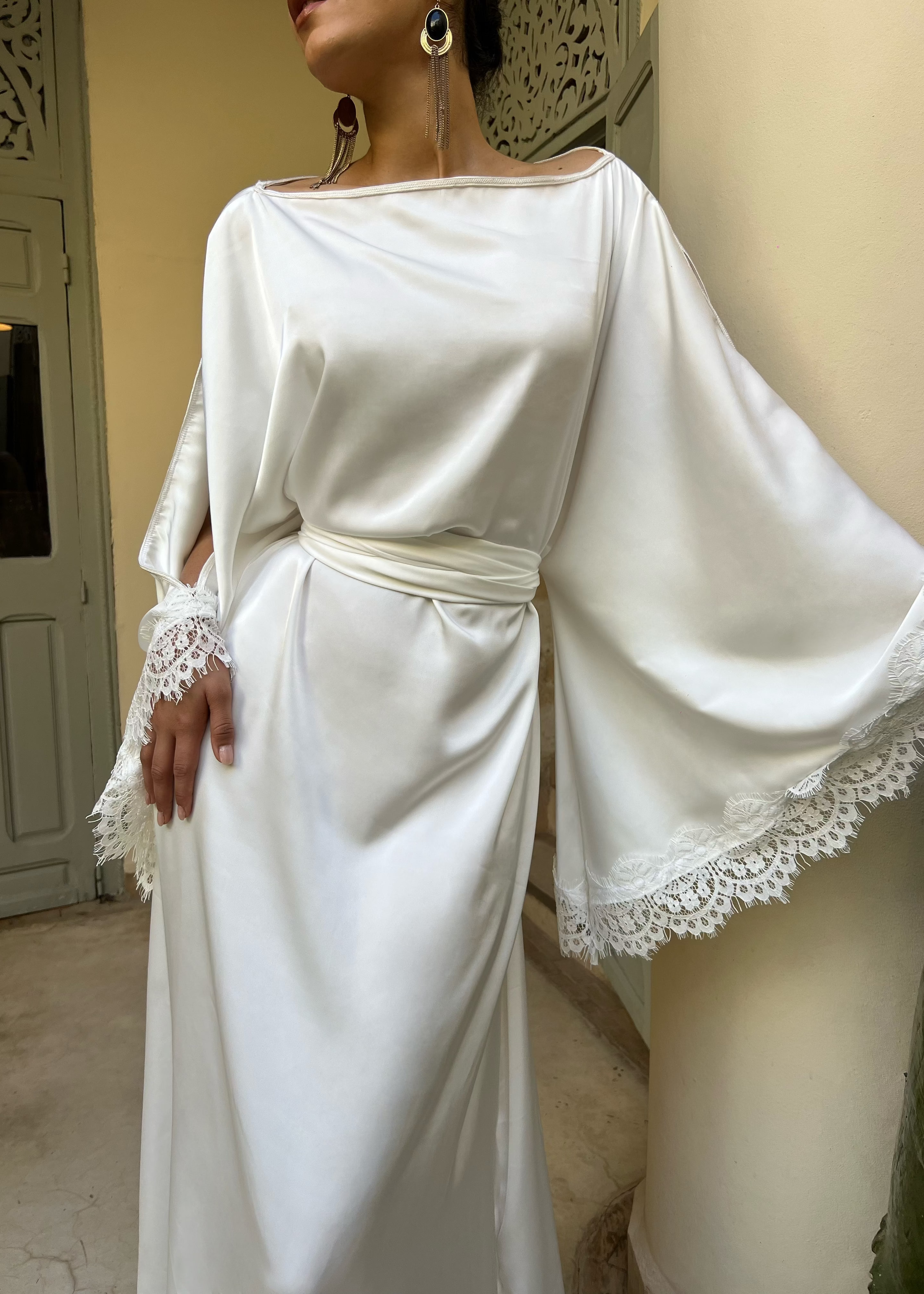 Détail du caftan de mariée en drap de soie blanc, bordure en dentelle et couture fine haute qualité