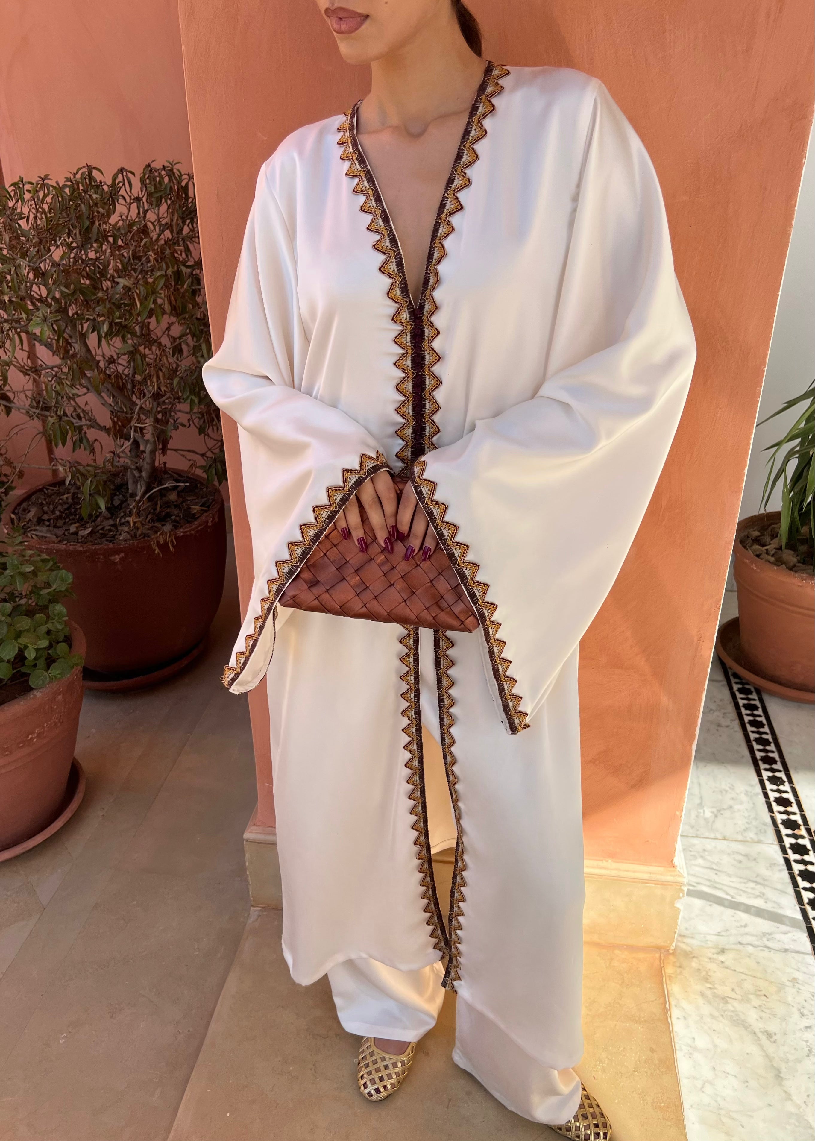 Tunique en drap de soie blanc avec broderie kabyle marron et orange portée par mannequin, style traditionnel revisité et chic