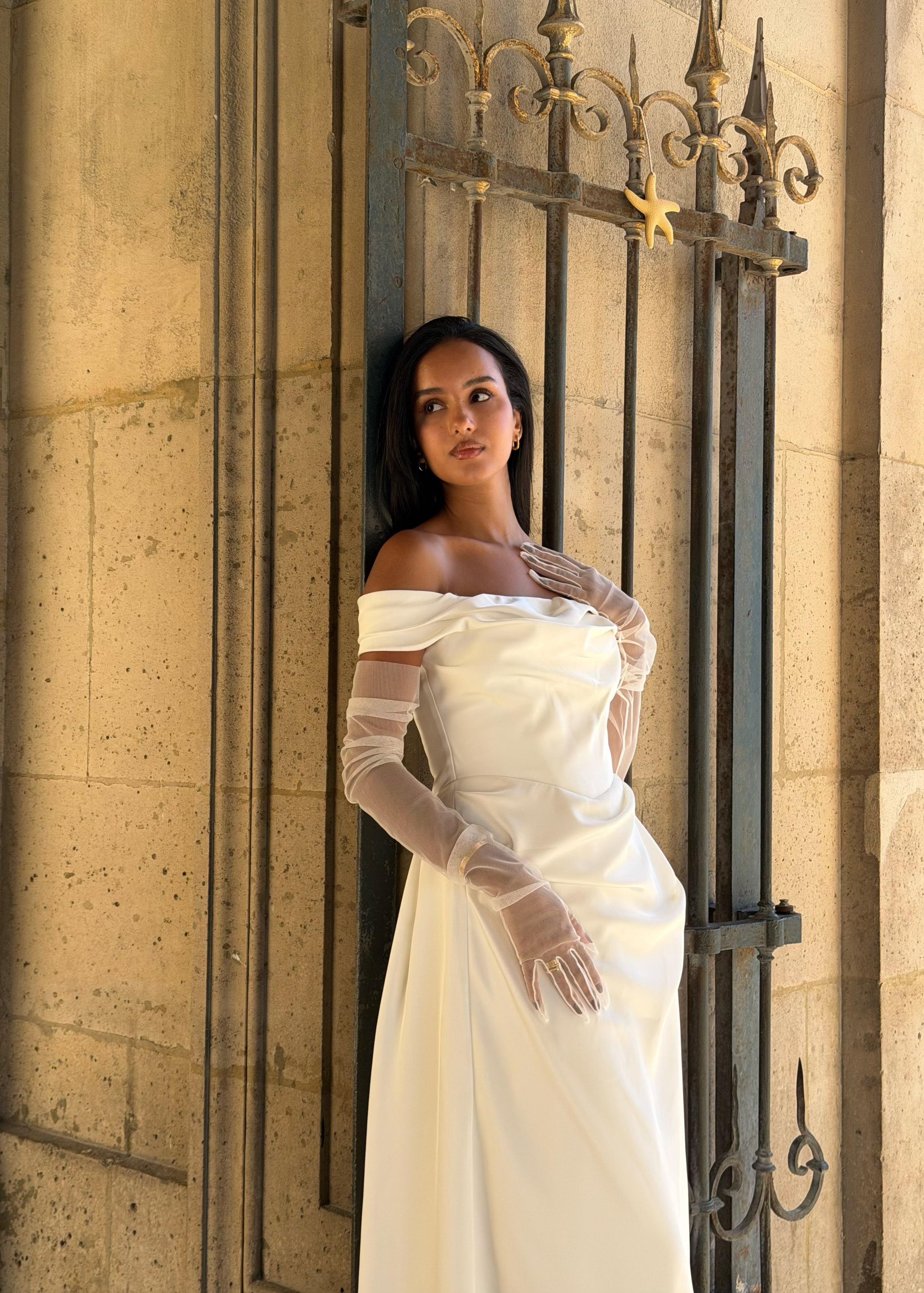 Vue de profil des manches en tulle transparent, apportant une touche aérienne à la tenue.