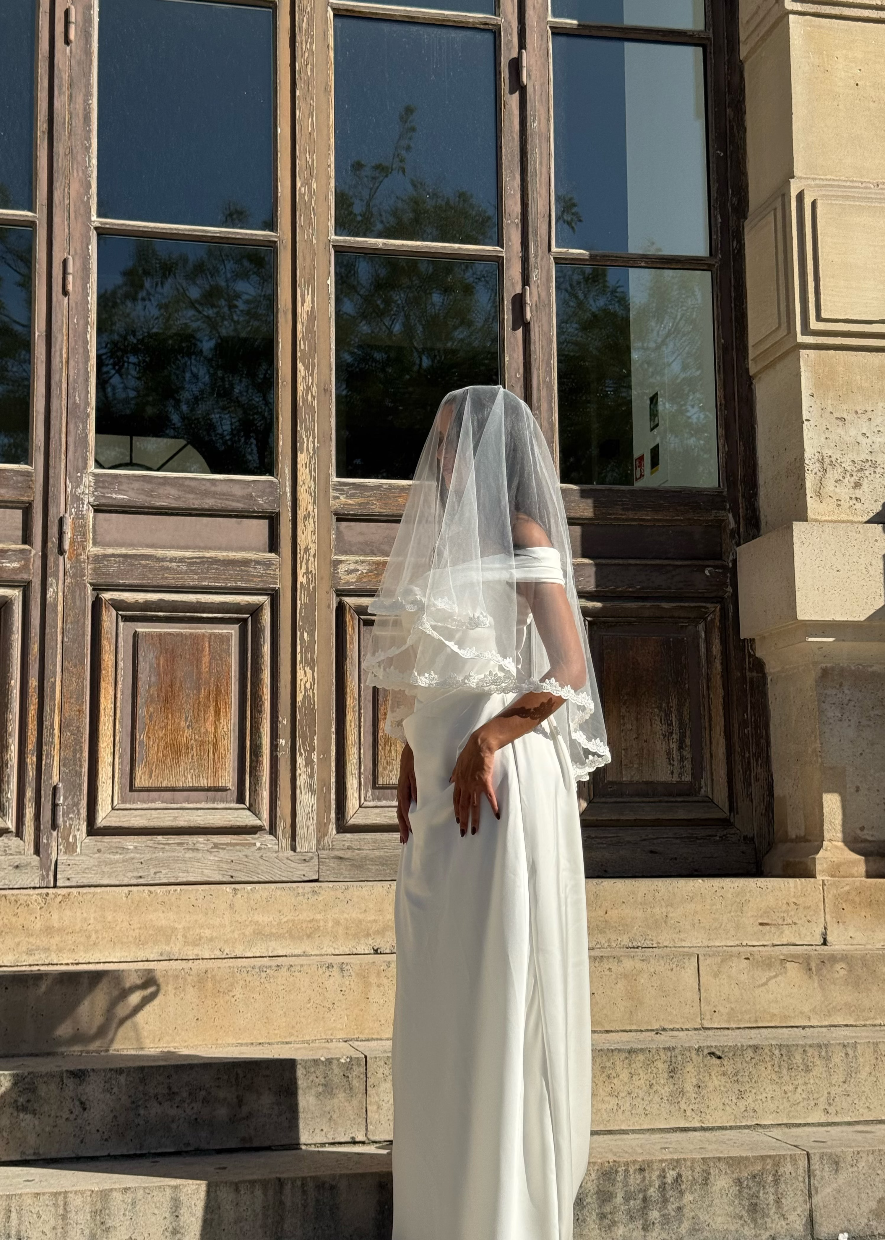 Voile de mariée court avec bordure en dentelle florale, vue de profil avec voile à l’arrière