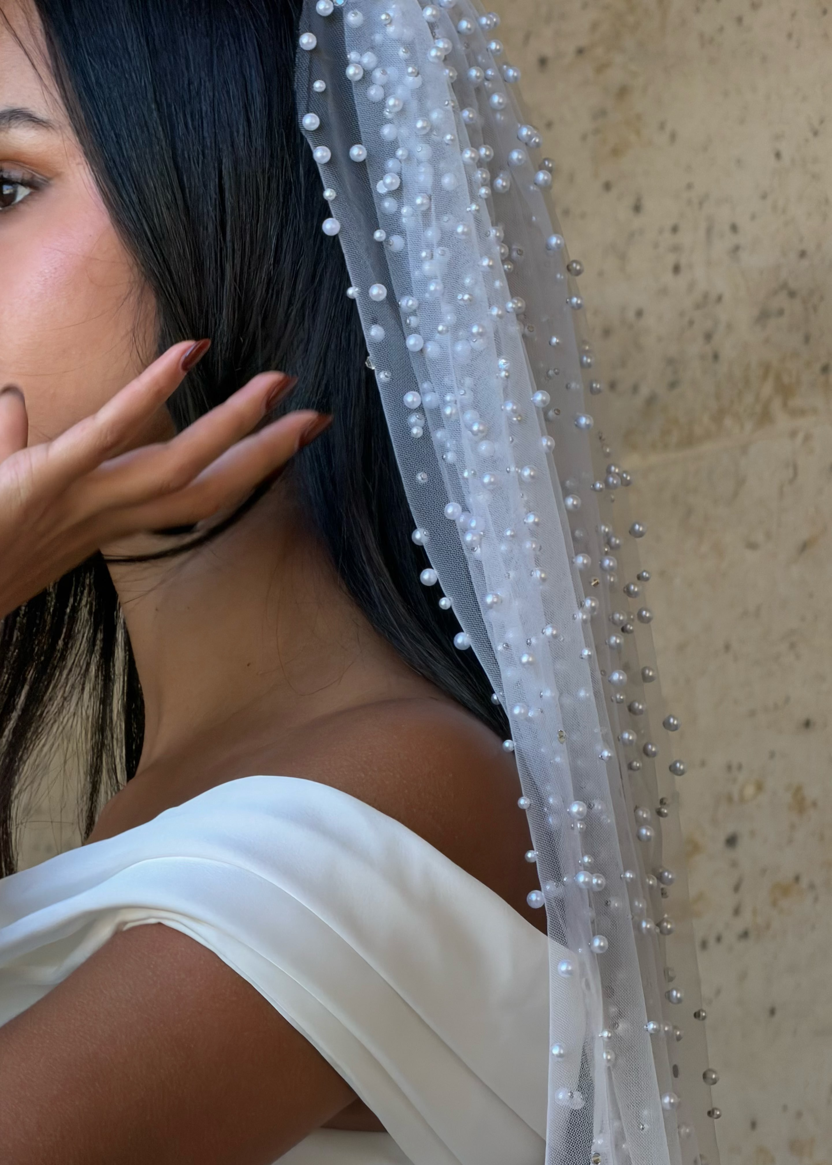 Gros plan sur les perles brodées à la main sur le tulle léger du voile de mariée.