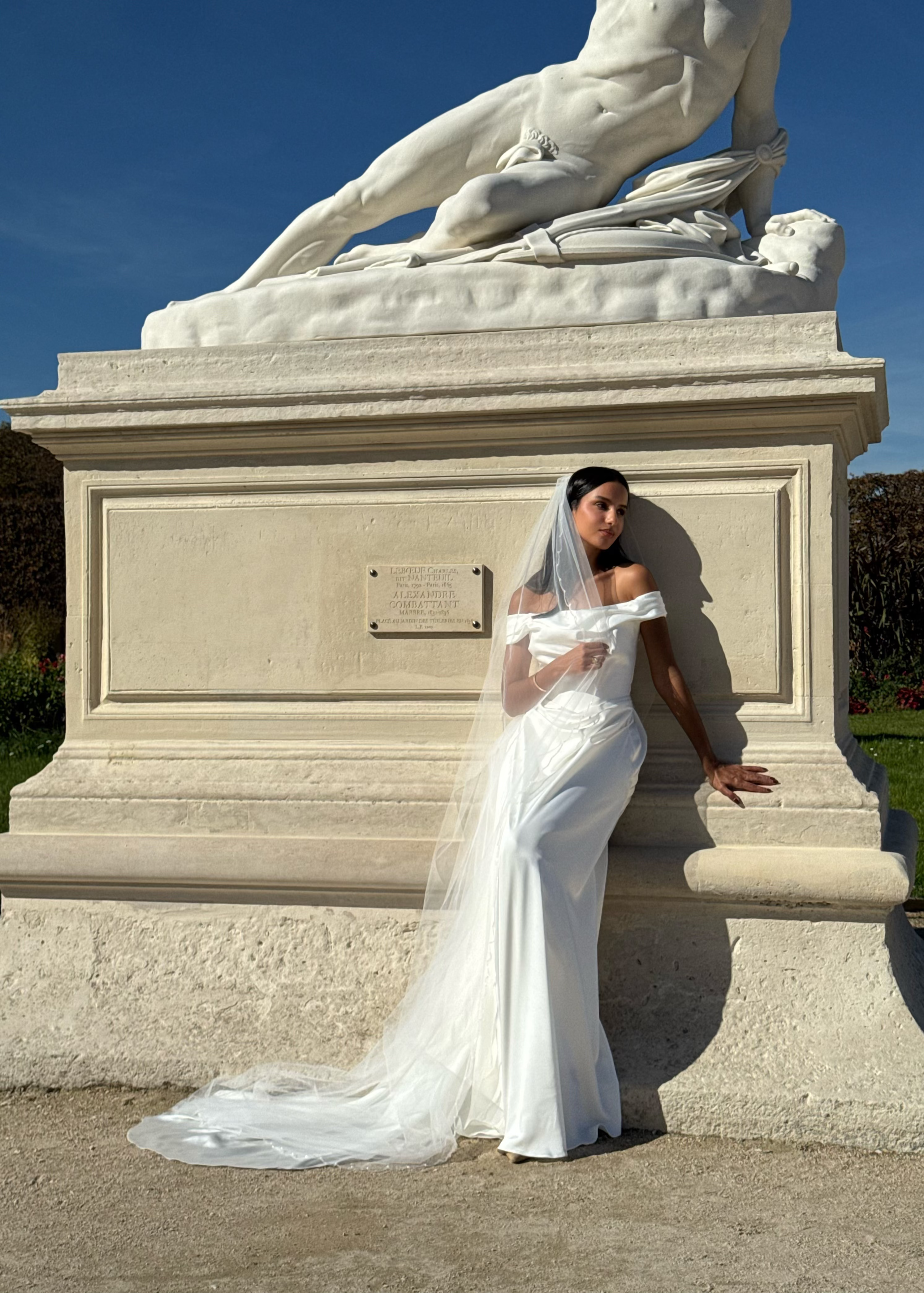 Profil d’une mariée avec voile long aux contours ondulés soulignés de perles délicates.
