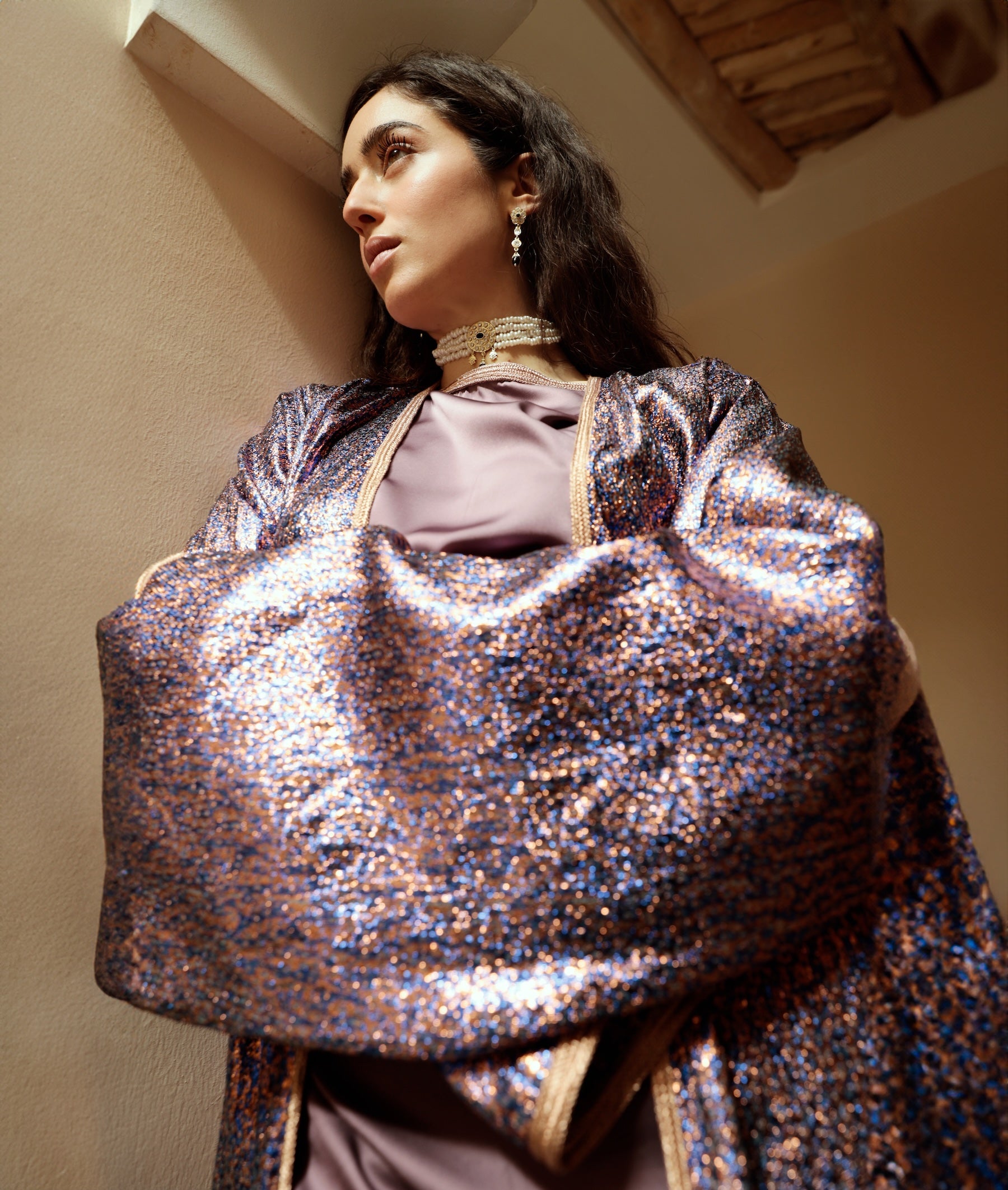 Detail of the kimono sleeve of an abaya in purple and blue lurex jacquard.