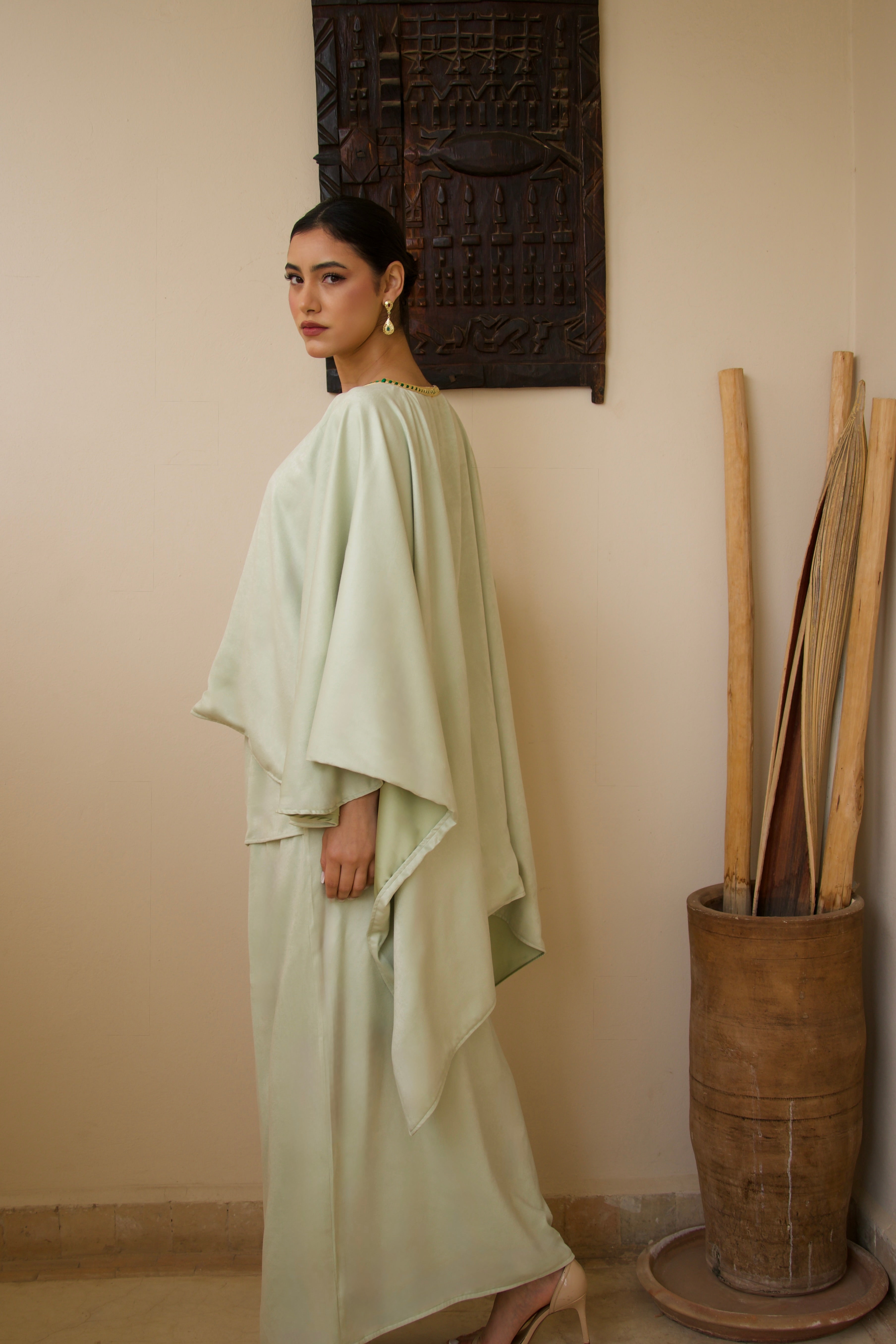 Green mlifa silk cape and skirt set worn in motion, flowing and elegant fabric.