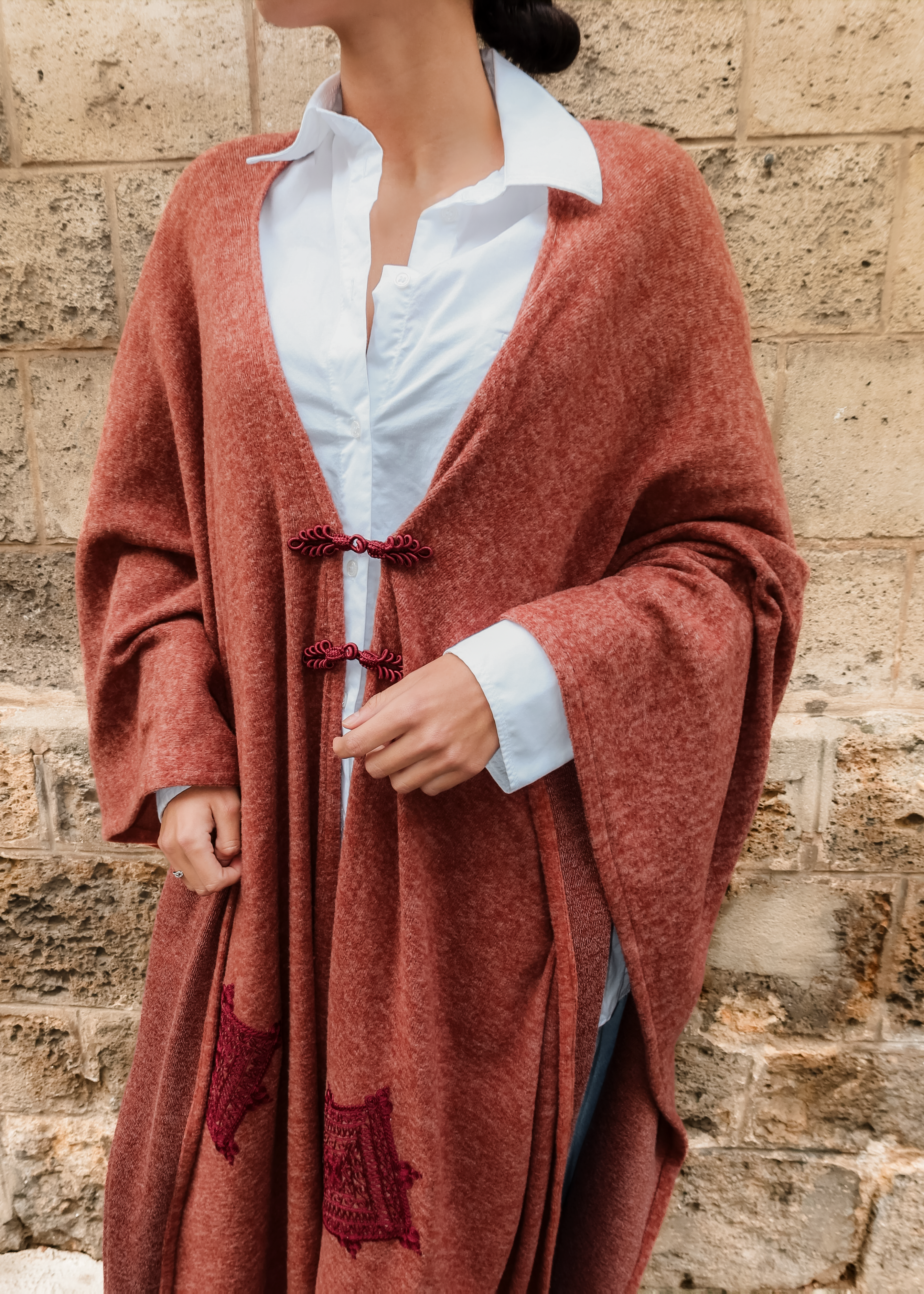 Long bohemian burgundy wool cardigan with oriental embroidery and Moroccan buttons worn in motion