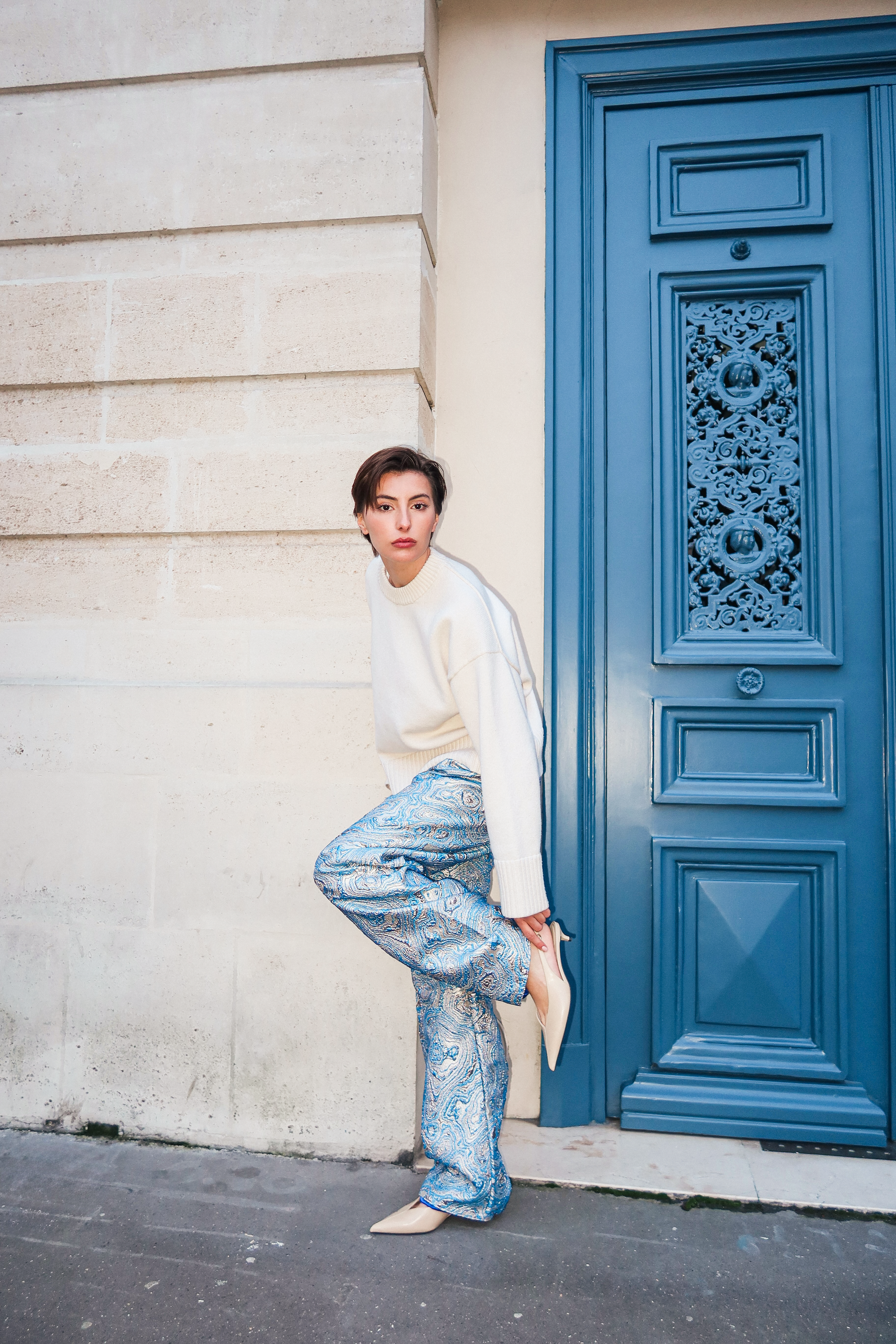 Blue brocade pants seen from the side, highlighting a structured straight cut