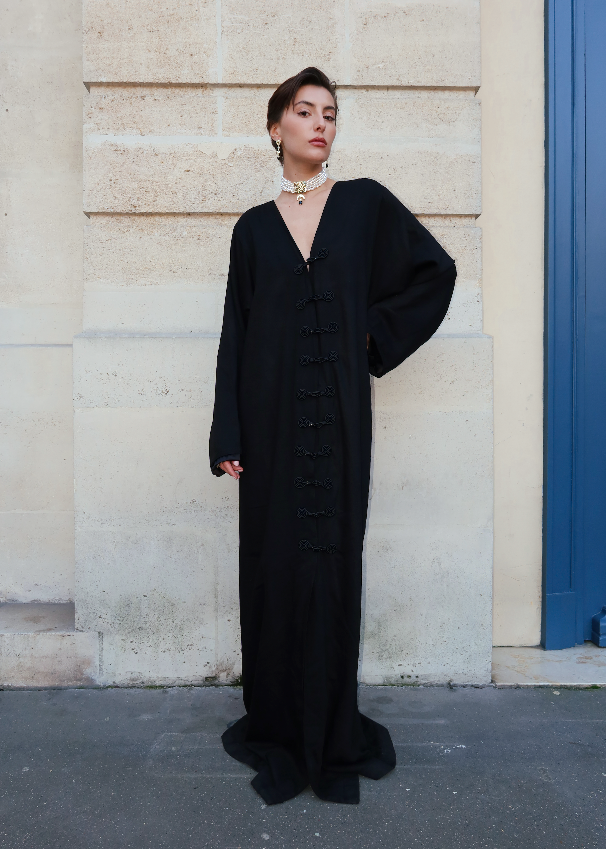Traditional black silk Mlifa dress photographed full length with elegant Moroccan hooks