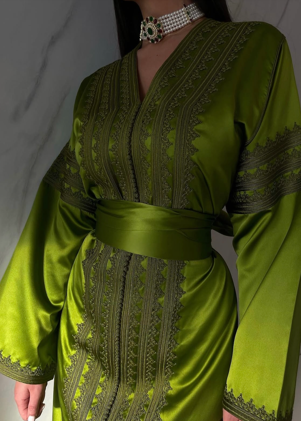 Zoom in on the Kaftan in green silk cloth, showing the texture of the fabric and the finesse of the handcrafted finish.