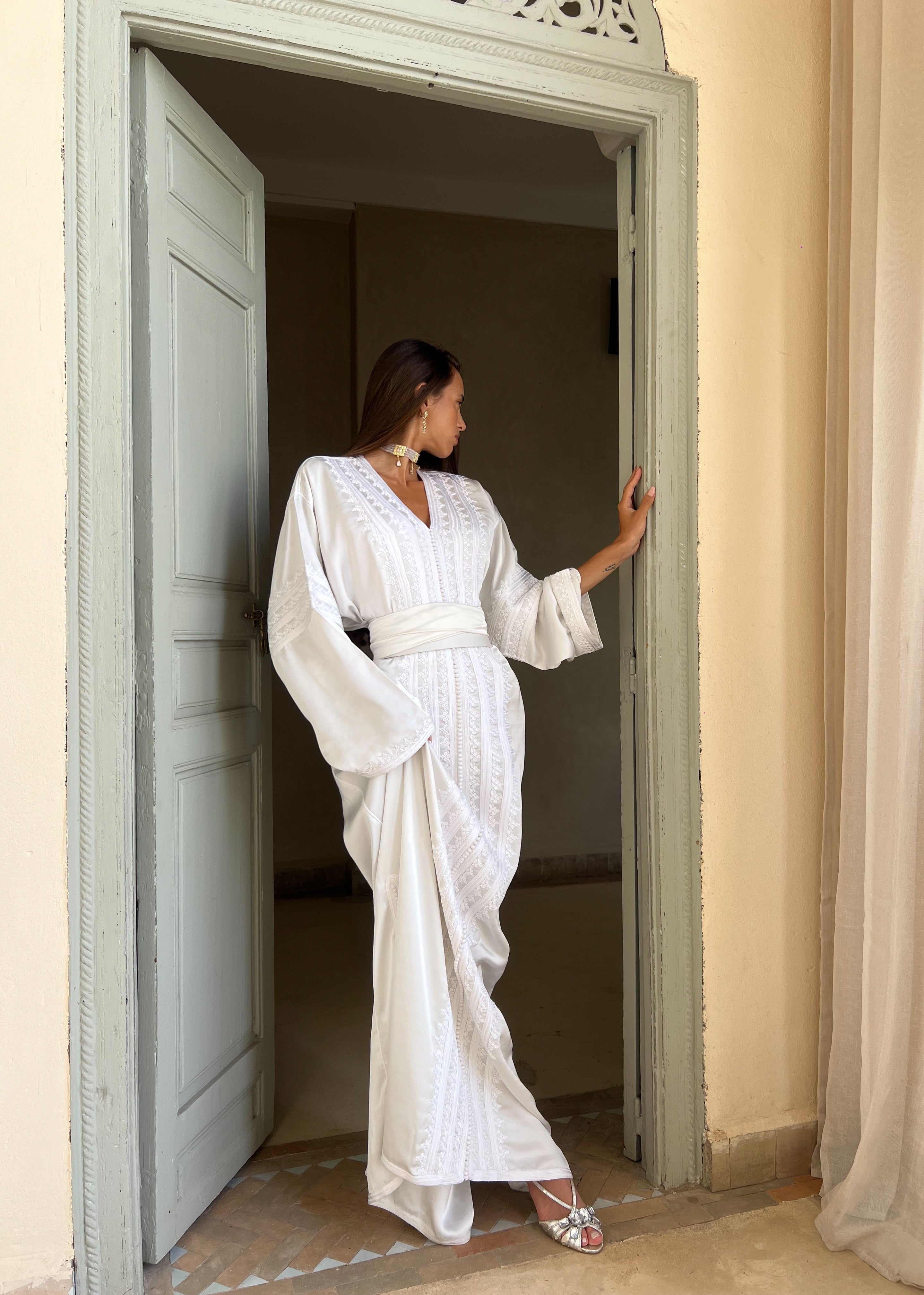Kaftan in white silk sheet captured in motion, highlighting the softness of the fabric and the grace of movement.