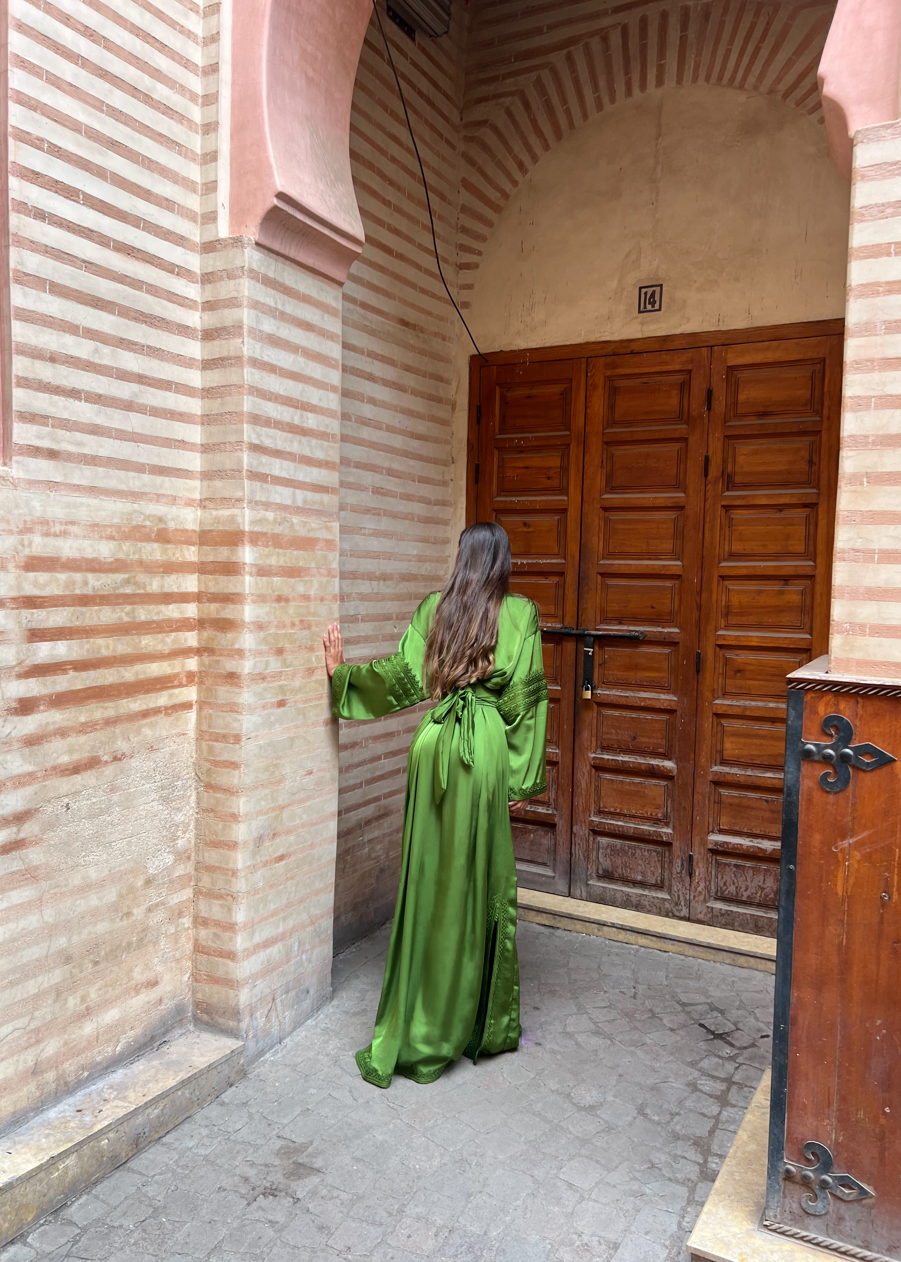 Kaftan in green silk drape seen from the back, emphasizing the softness of the drape and the lightness of the fabric.