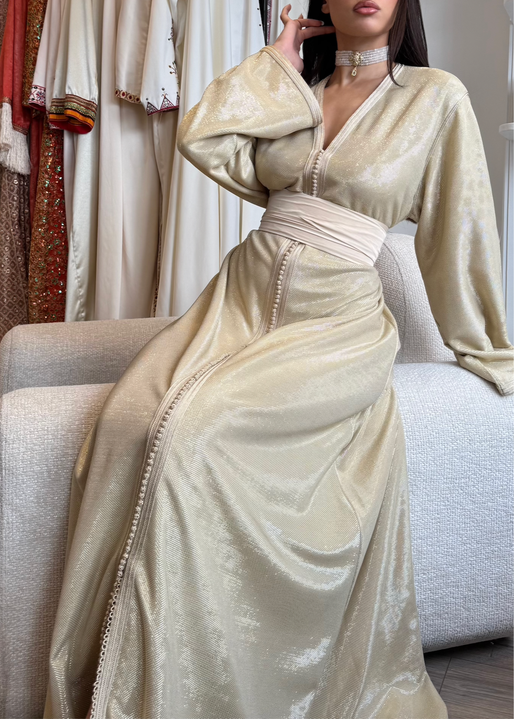 Kaftan in beige silk lamé seen in profile, revealing the silky texture and elegant fluidity of the cut.