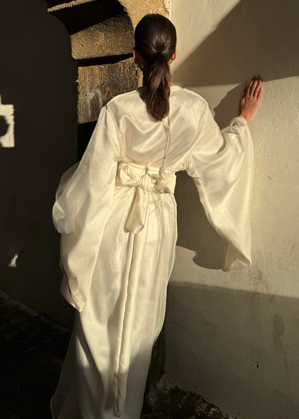 Bridal Kaftan in white organza seen from the back, revealing the lightness of the fabric and the finesse of the finishing touches.