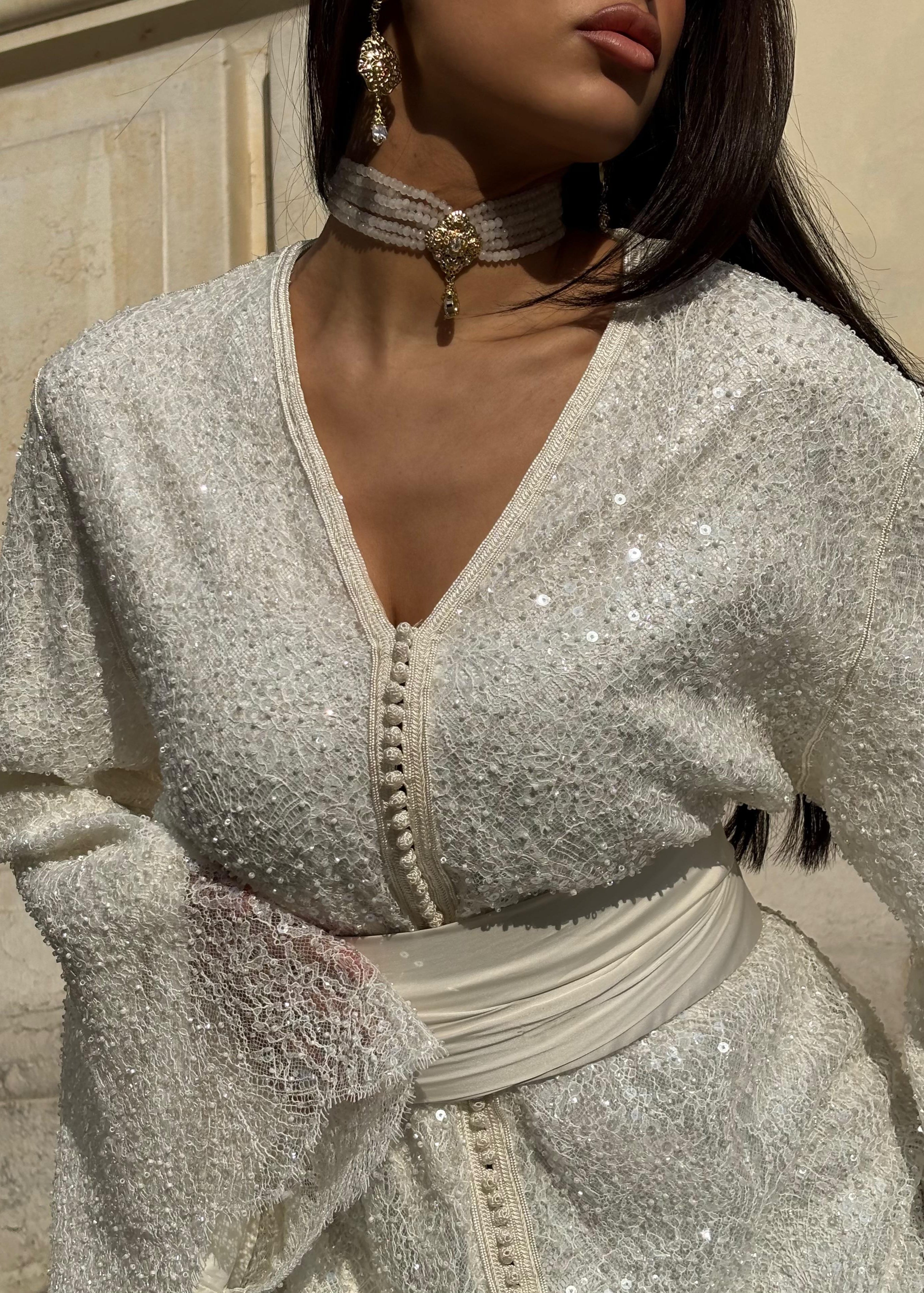 Beaded bridal Kaftan with flared sleeves captured in motion, highlighting the lightness of the fabric and the sparkle of the pearls.