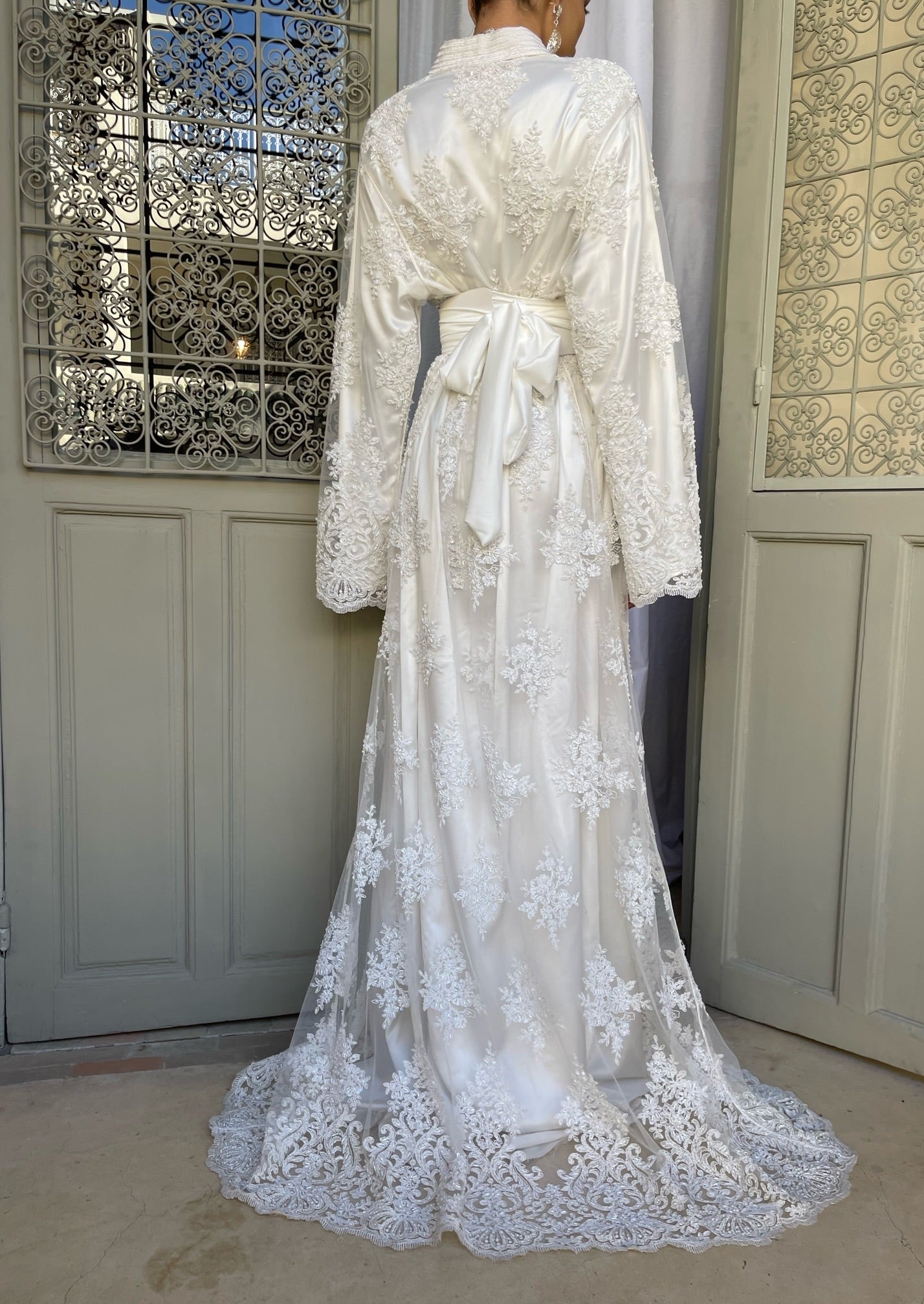 Bridal Kaftan in pearled tulle with officer collar seen from the back, revealing the delicate transparency of the tulle and the finesse of the pearls.