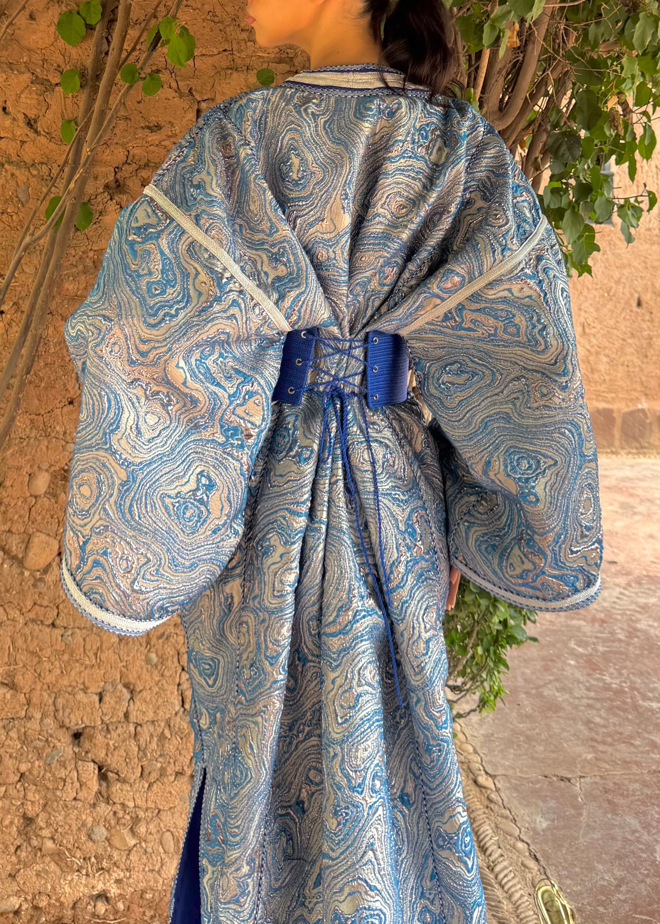 Back view of the modern Kaftan in blue brocade, highlighting the cut and finish.